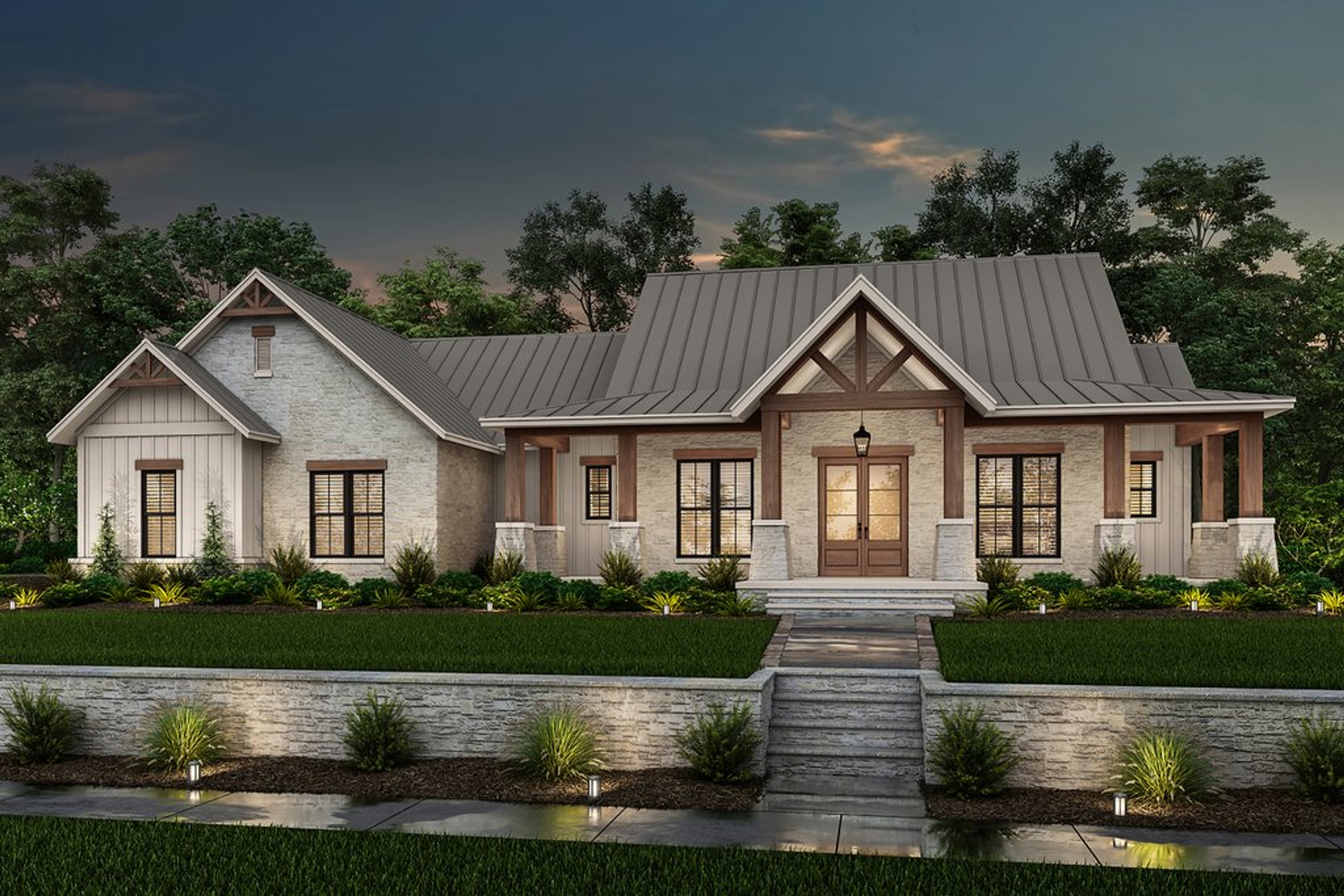 A modern home with a tan exterior and metal roof lit up at sunset.