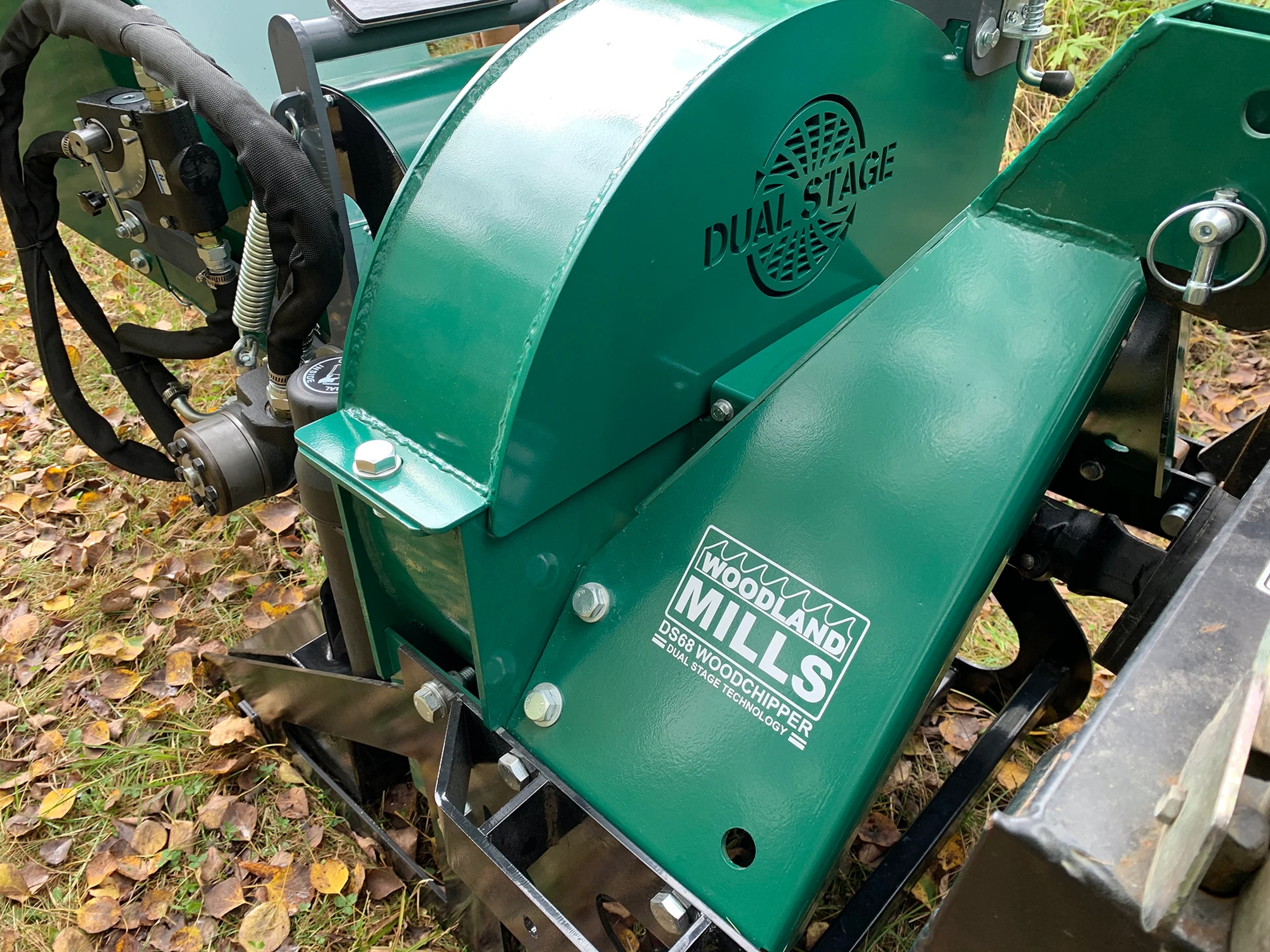 A green Woodland Mills woodchipper on a lawn with leaves