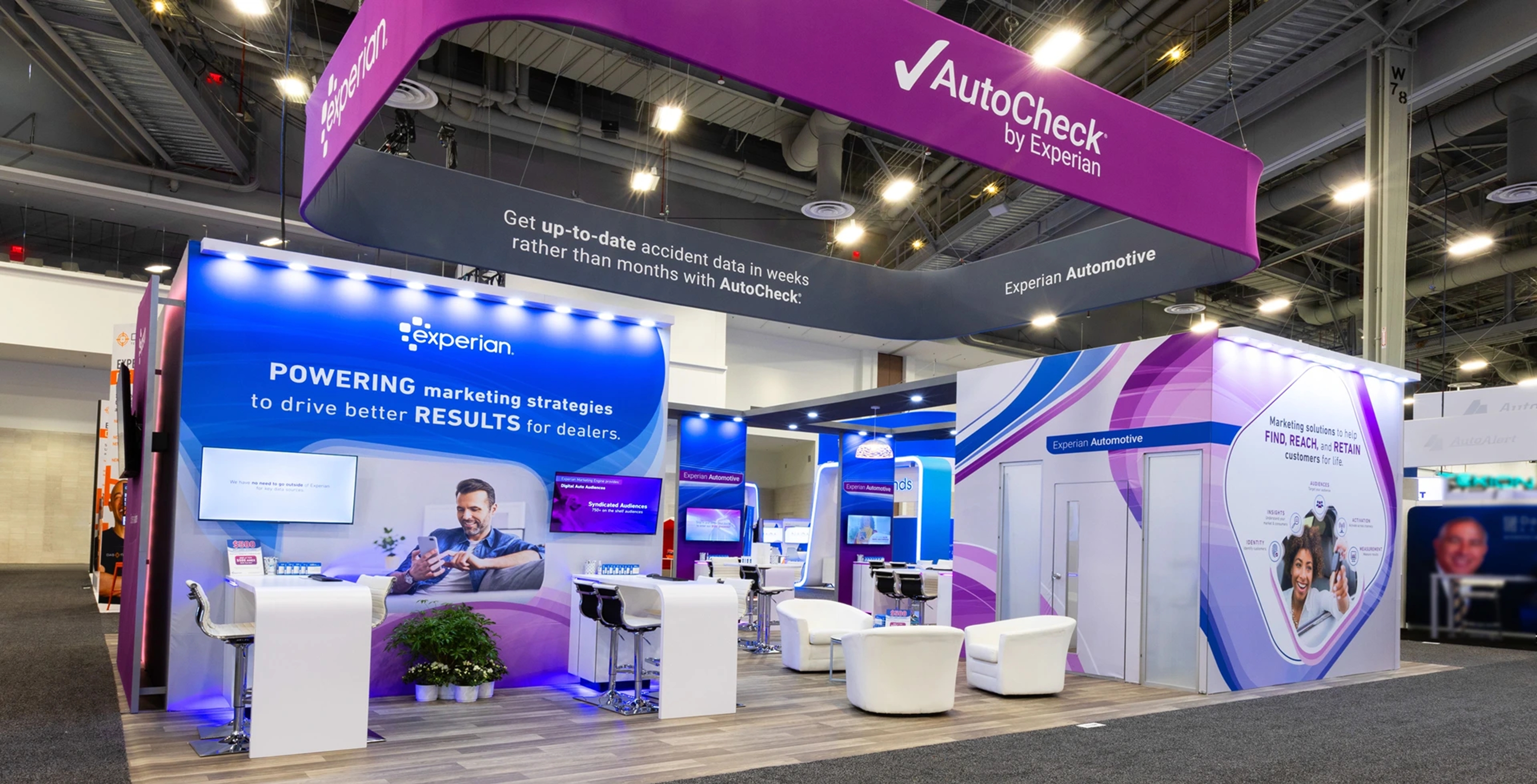 A business event with a marketing display and booth with tables and chairs for Experian.