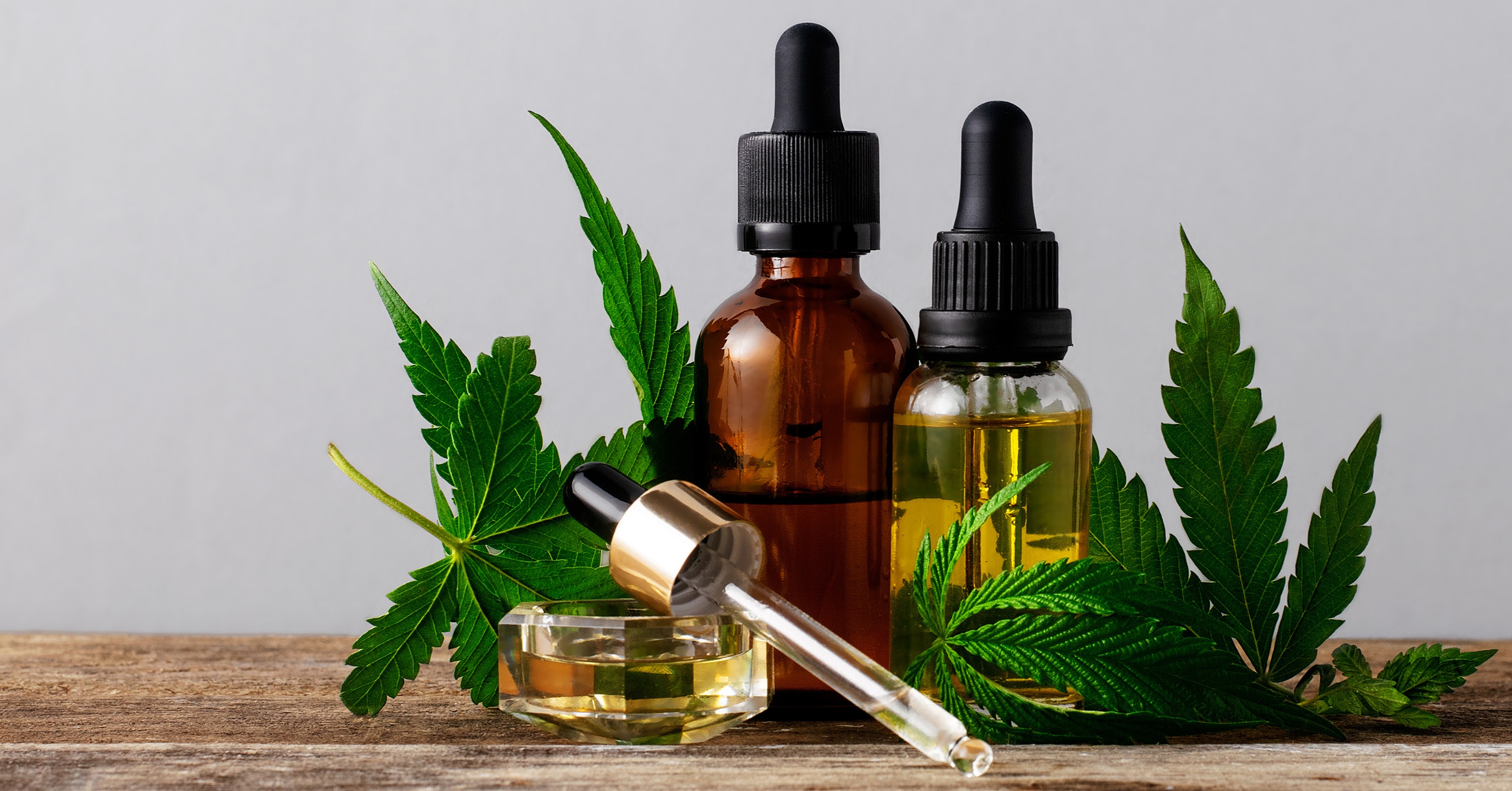 A selection of dropper bottles with cannabis leaves on a white counter