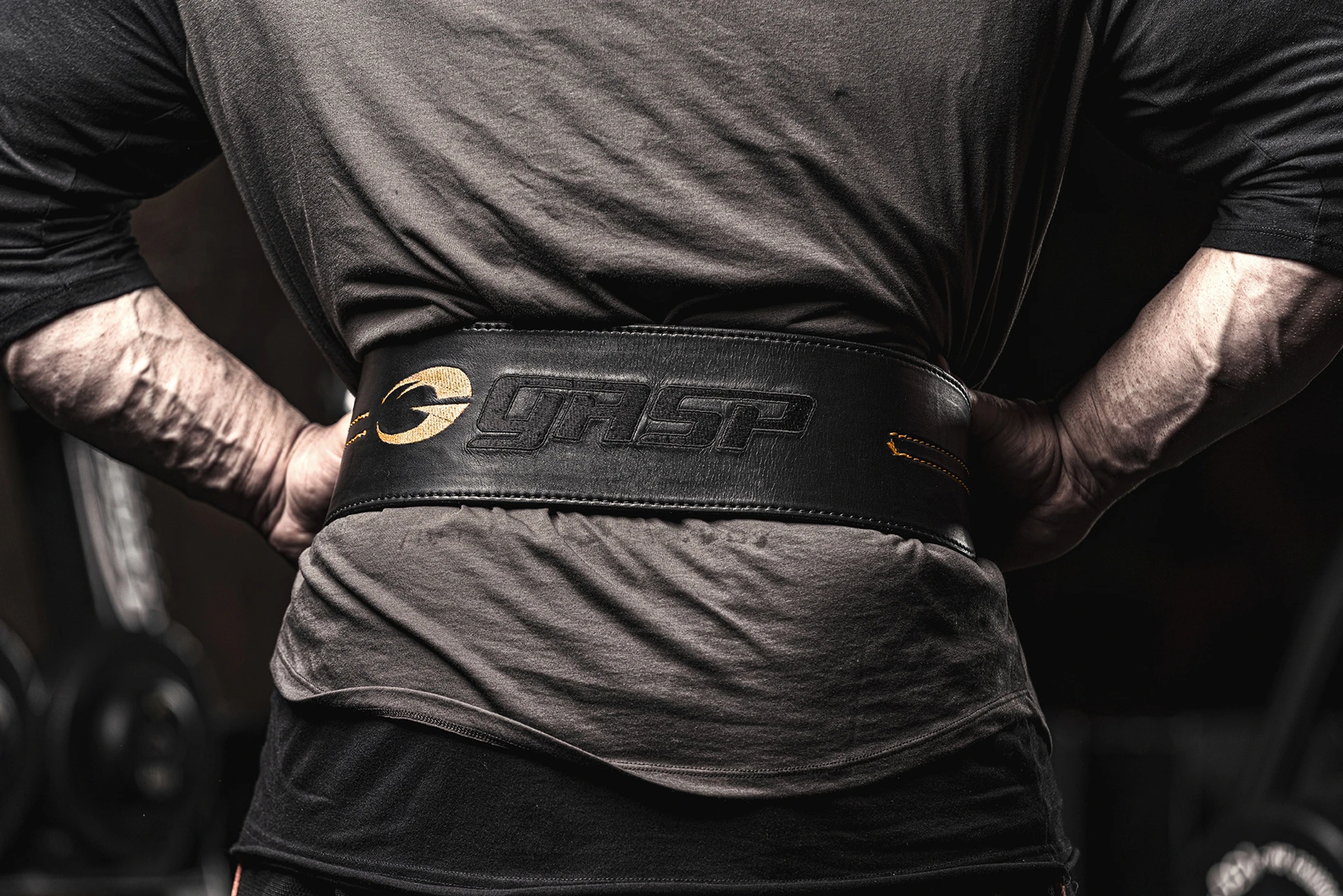 A man with a black Gasp workout and lifting belt.