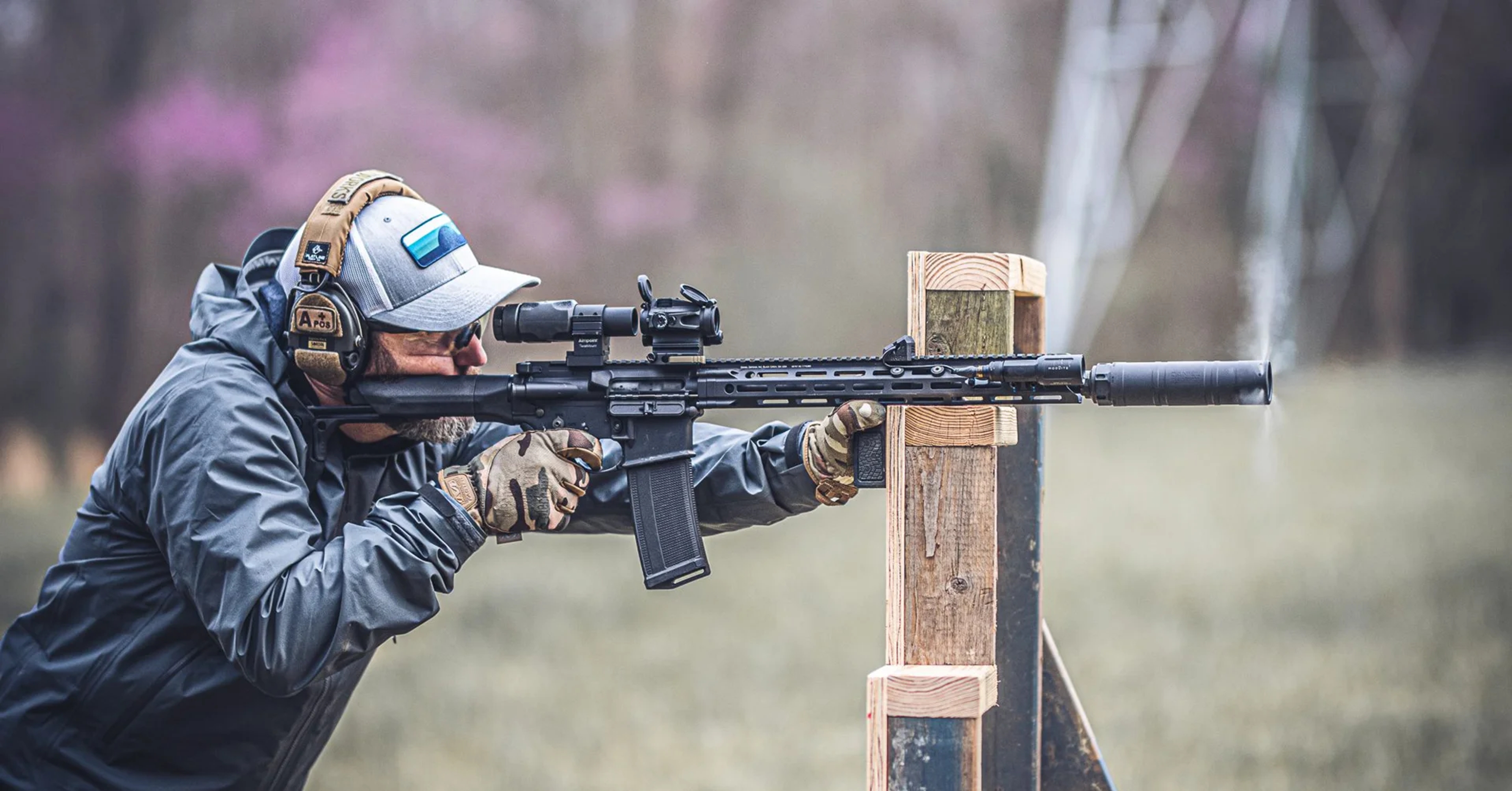 A man practicing his aim with a rifle outside.