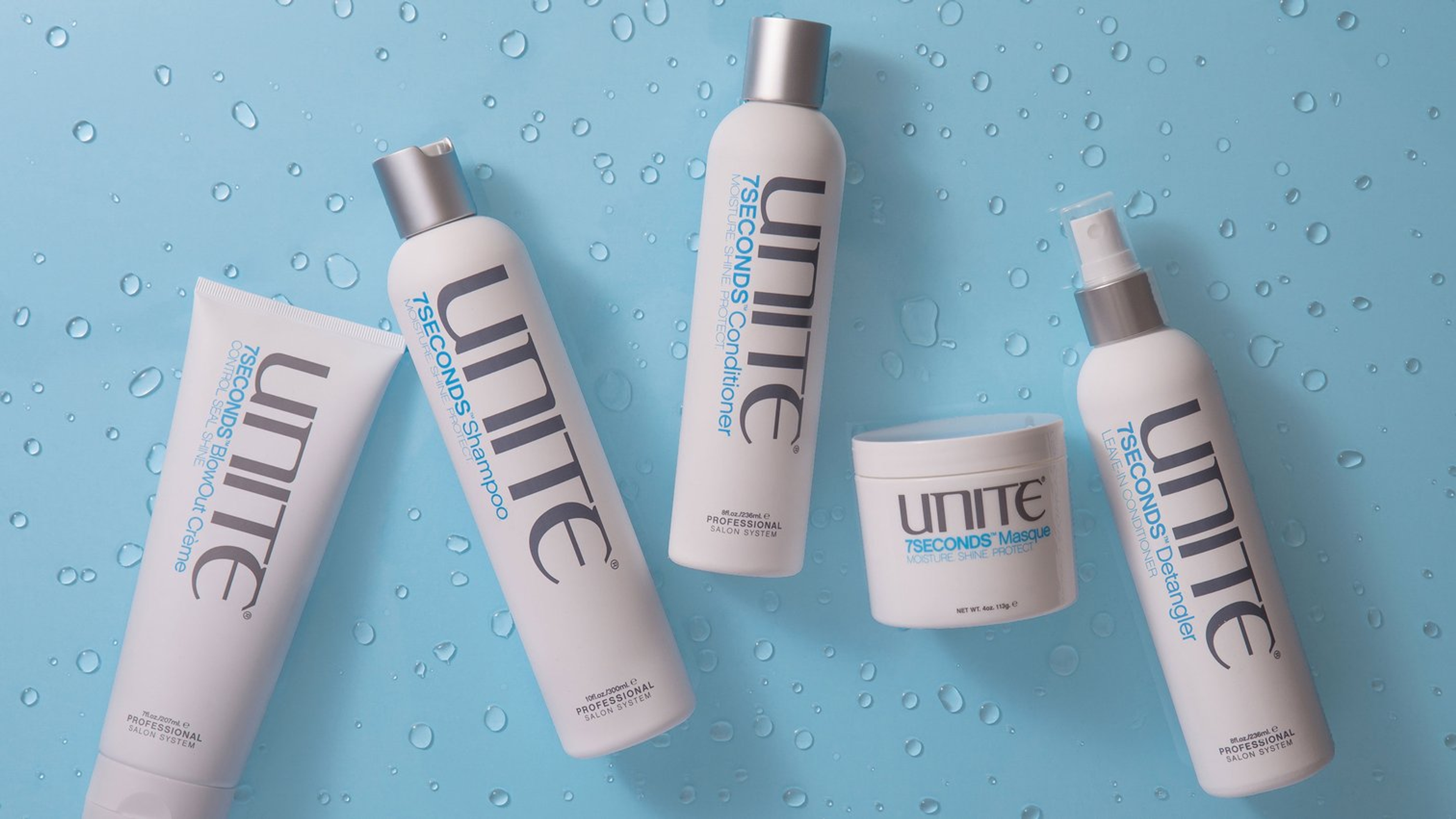 bottles of UNITE Hair products on a blue surface