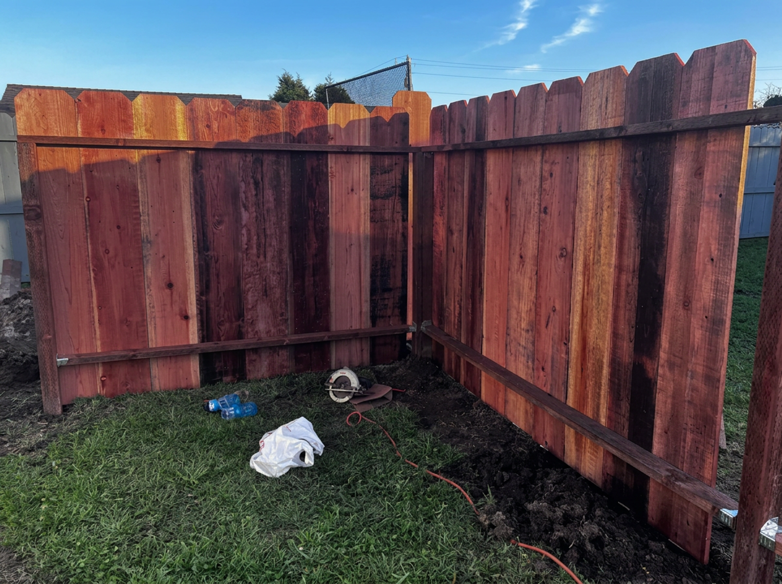 Freshly stained redwood fence panels in a Watsonville backyard