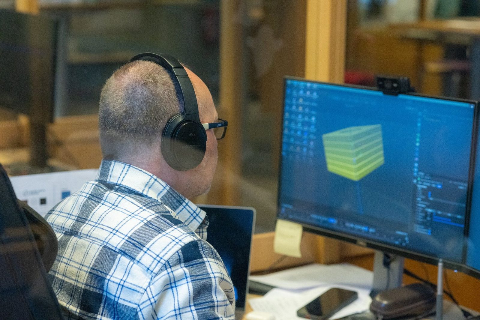 Animatør med hodetelefoner jobber med en 3D-modell