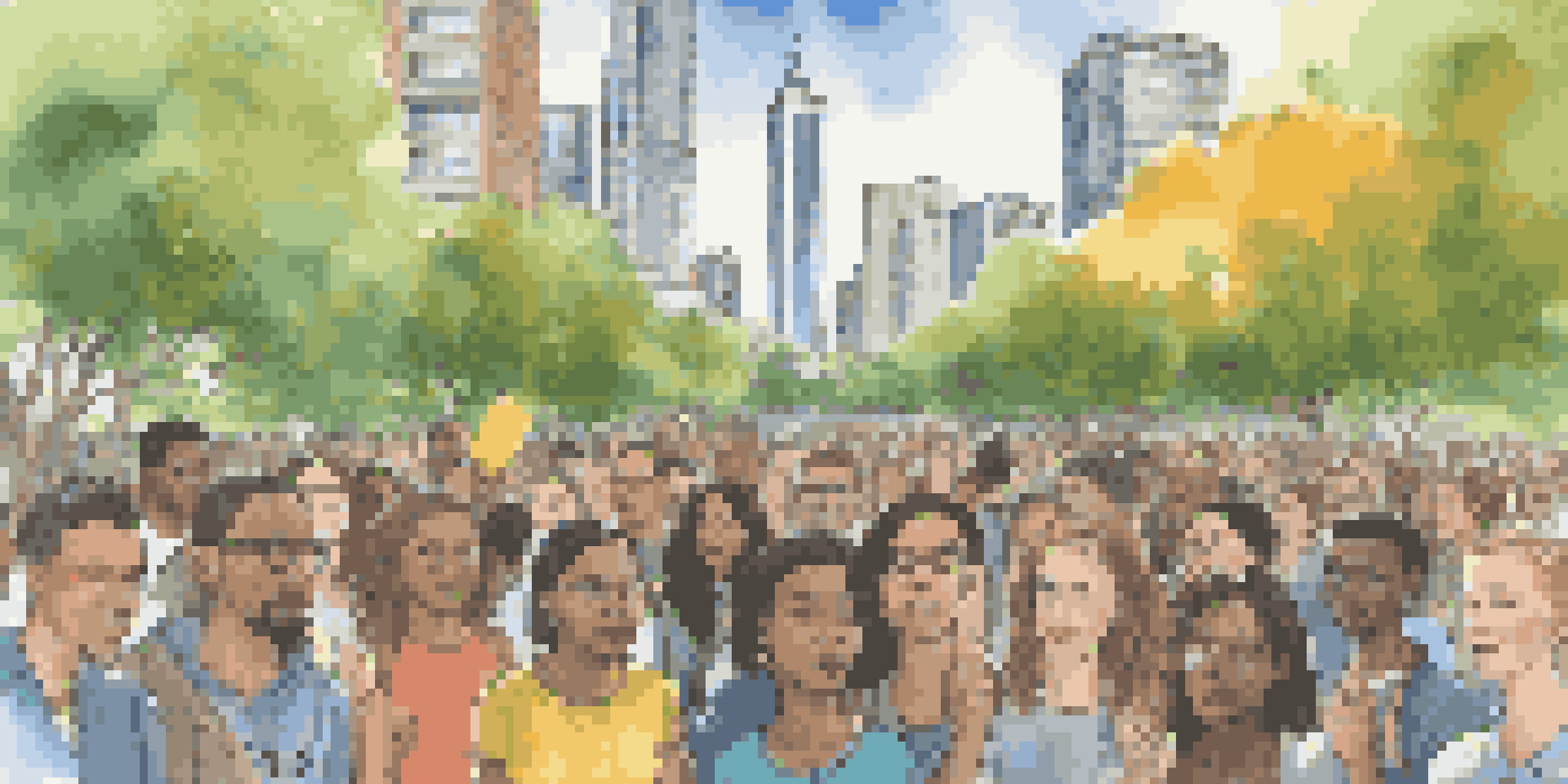 A diverse group of young activists in a park, holding signs for climate action, surrounded by greenery and city buildings.