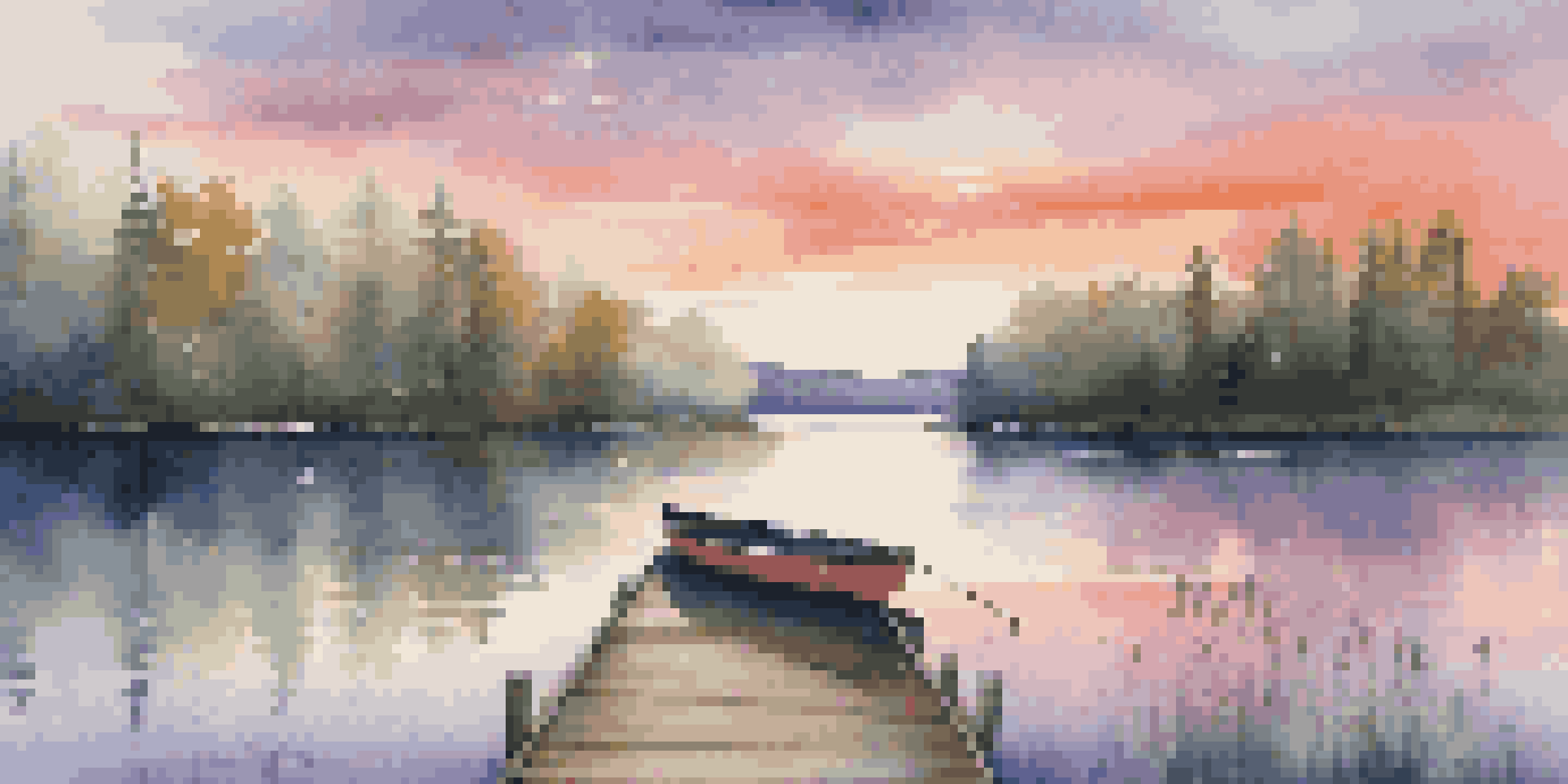A tranquil lake surrounded by green forests at sunset, with vibrant colors in the sky reflecting on the water and a wooden dock in the foreground.