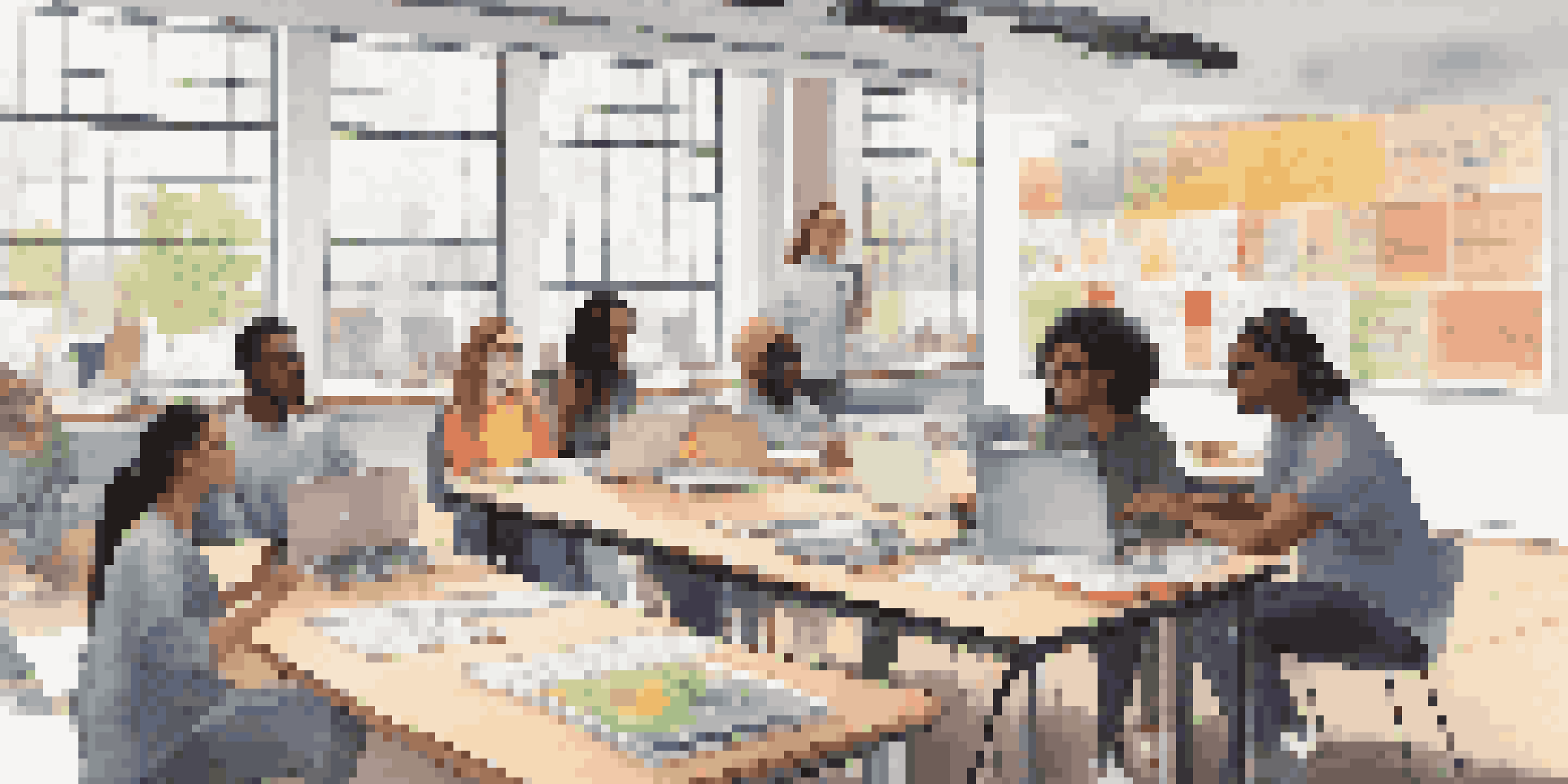 A diverse group of students studying together online, with laptops and notes on a large table, in a bright and modern room.