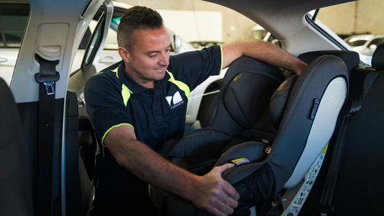 motorserve mechanic installing child restraint in car