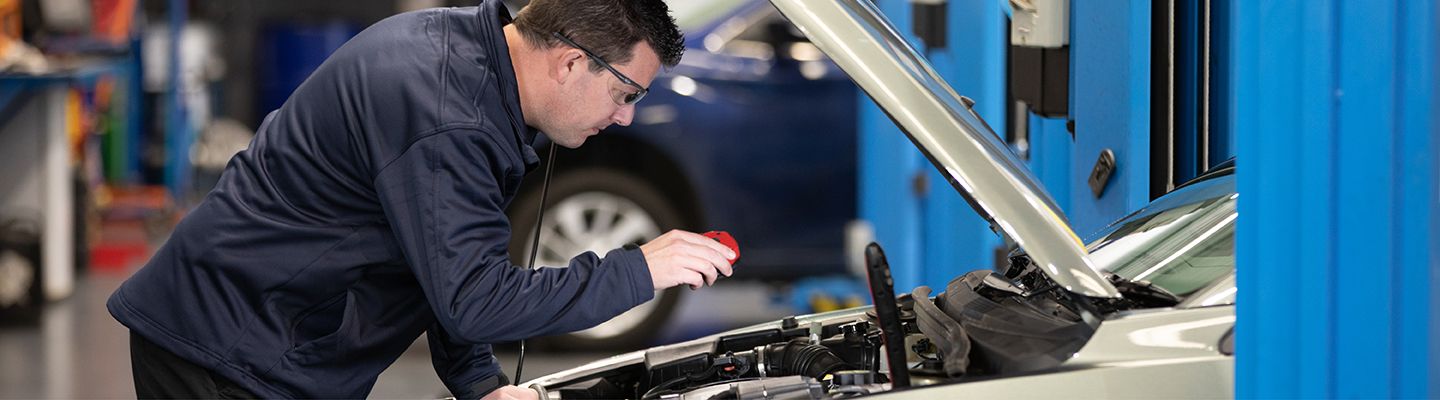 Mechanic inspecting under the car bonnet