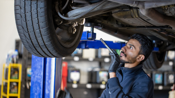 motorserve mechanic in workshop next to silver car