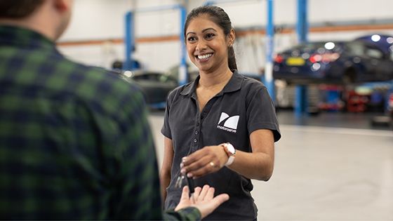 female mechanic handing customer car keys 