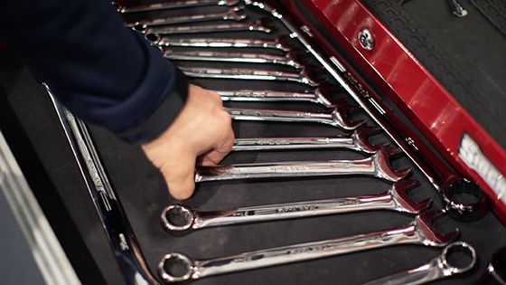 hand reaching for wrenches