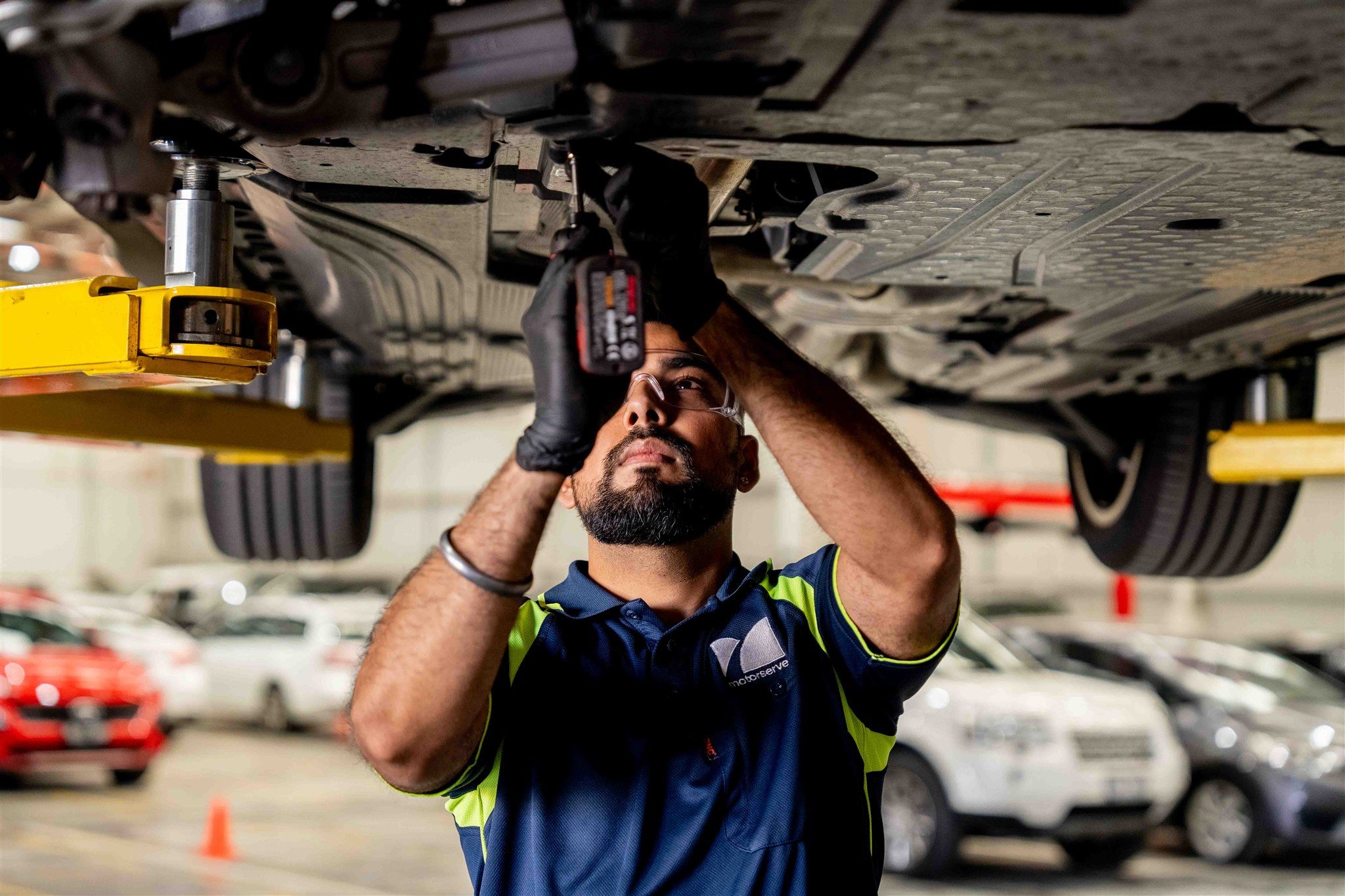 male mechanic working under vehicle
