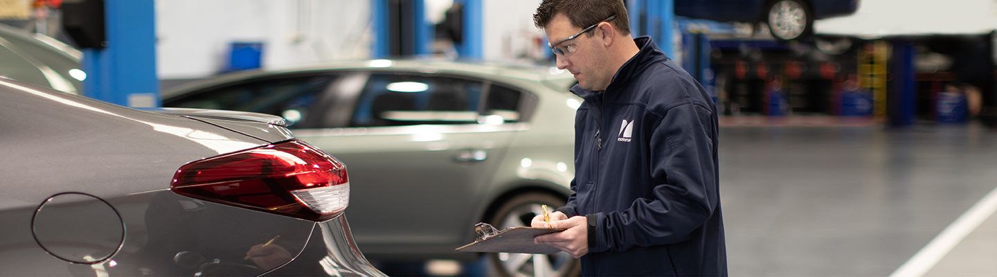 mechanic inspecting car in workshop