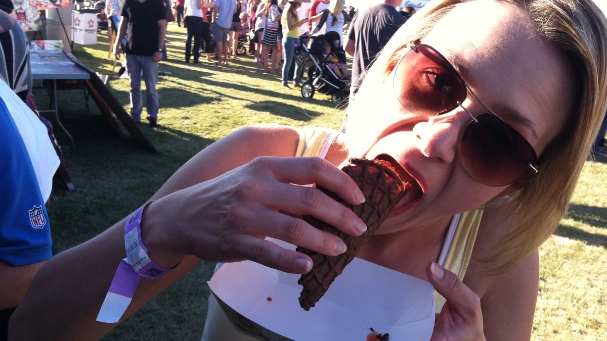 Attendee eating a Dessert Taco with chocolate shell, avocado mousse, ice cream, and candied tortilla strips.