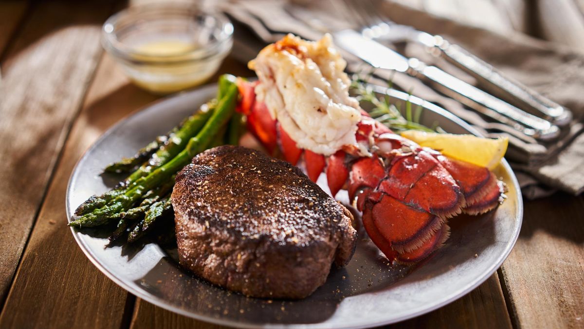 tasty surf & turf steak and lobster meal with asparagus on dinner plate