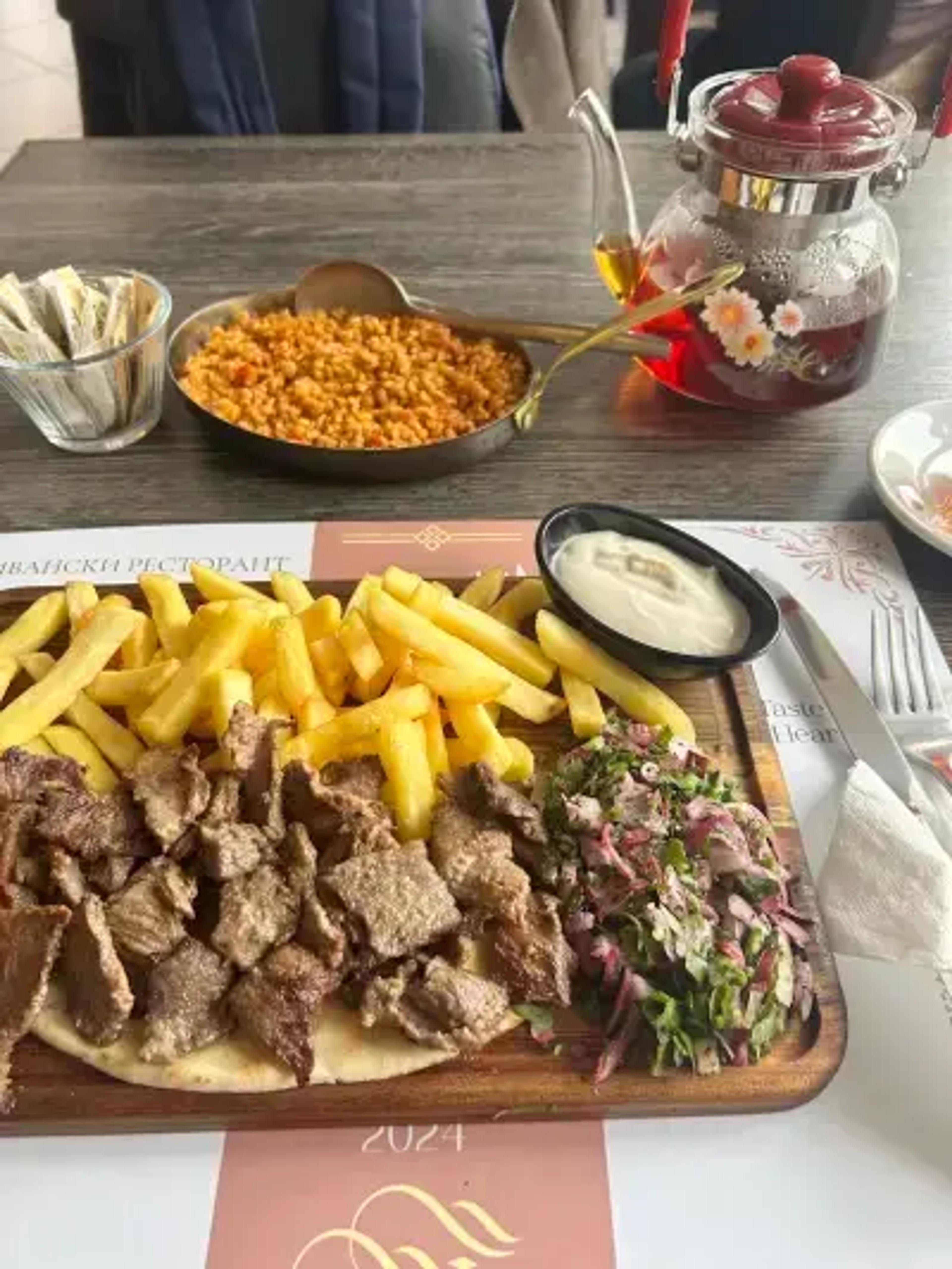 Плато с печено месо, пържени картофи и салата.