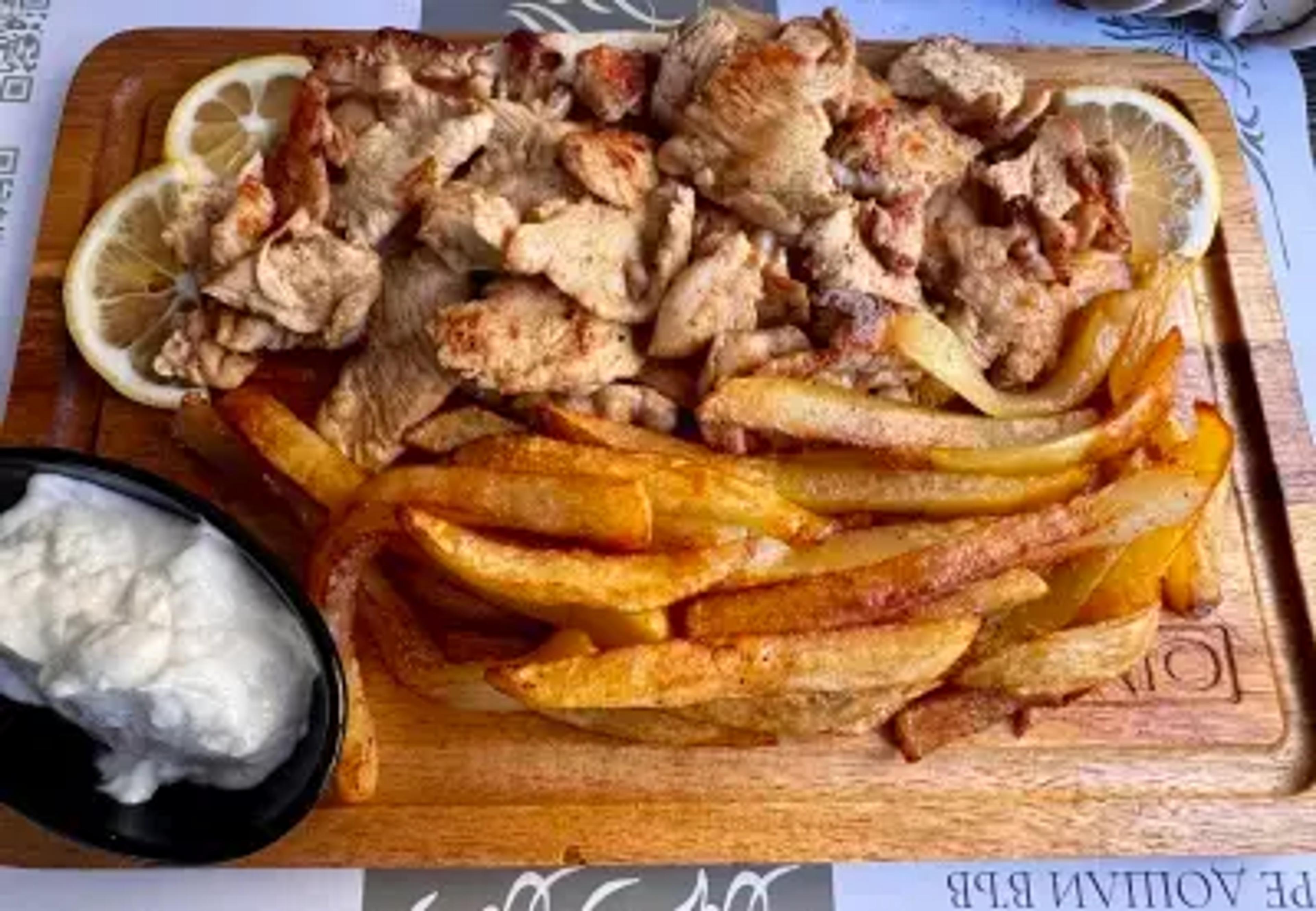Късчета печено пилешко месо с пържени картофи.