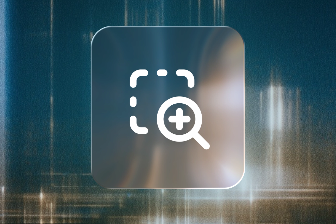 Magnifying glass with a plus sign beside a dashed selection frame on a frosted glass tile