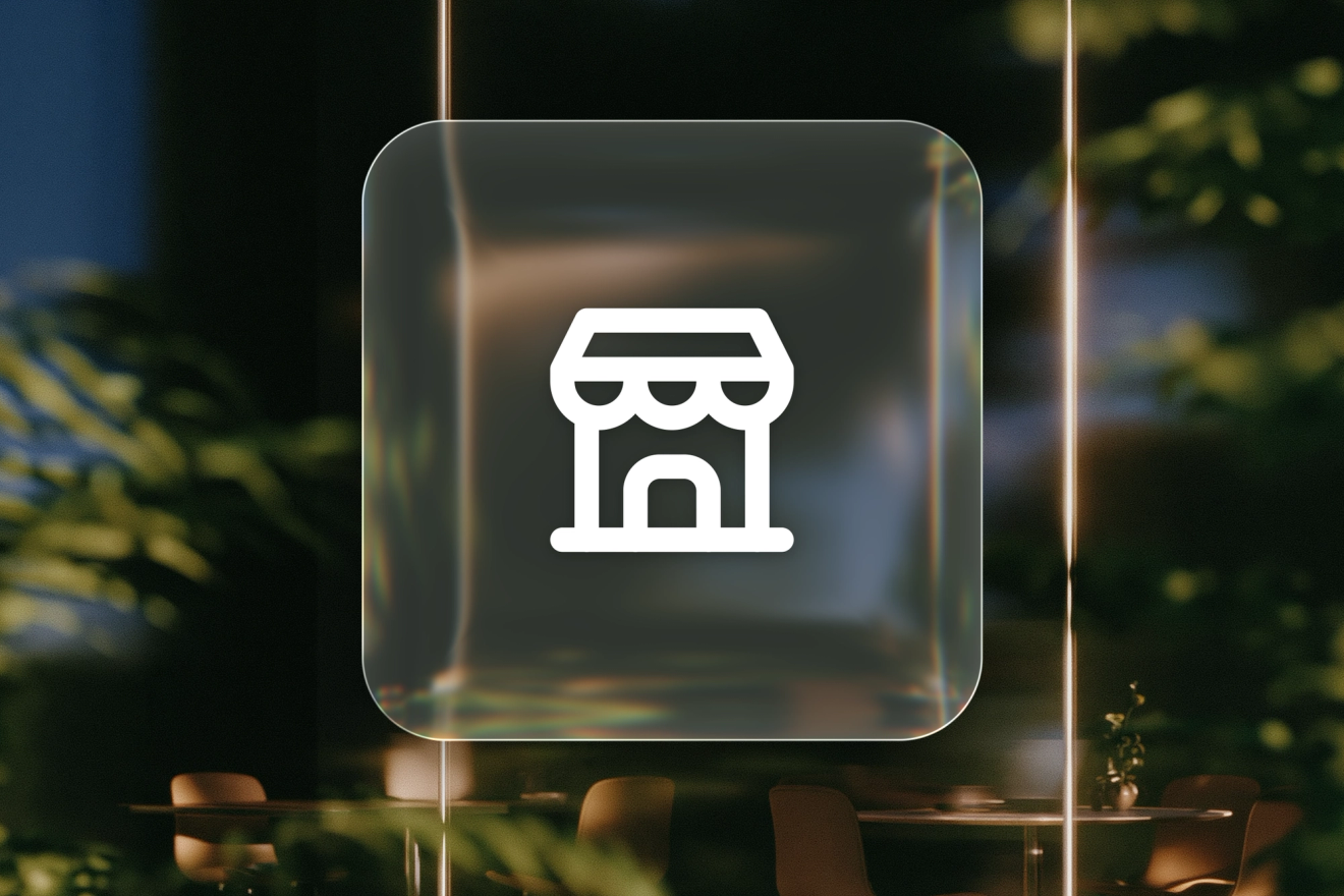 A white storefront icon on a frosted-glass tile over a softly lit office interior.