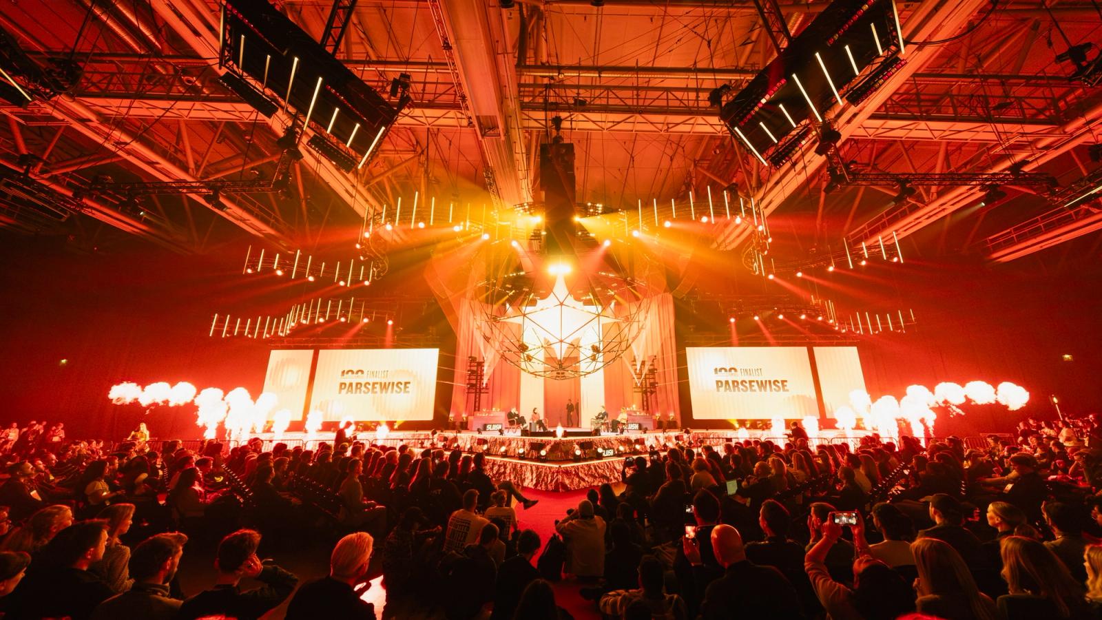 A packed audience faces the Founder Stage, lit in red, during the Slush 100 Finals at Slush 2025 in Helsinki.