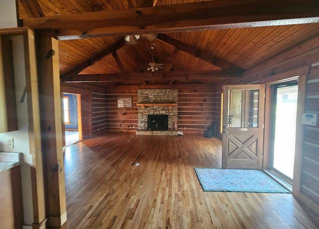 The Lodge — great room with stone fireplace and vaulted log ceiling