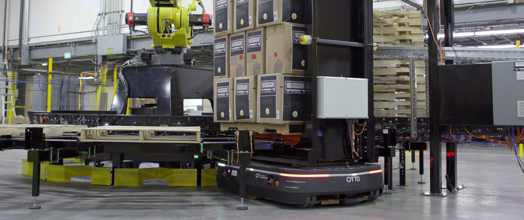 OTTO 1500 autonomous mobile robot delivering boxes to a palletizer.