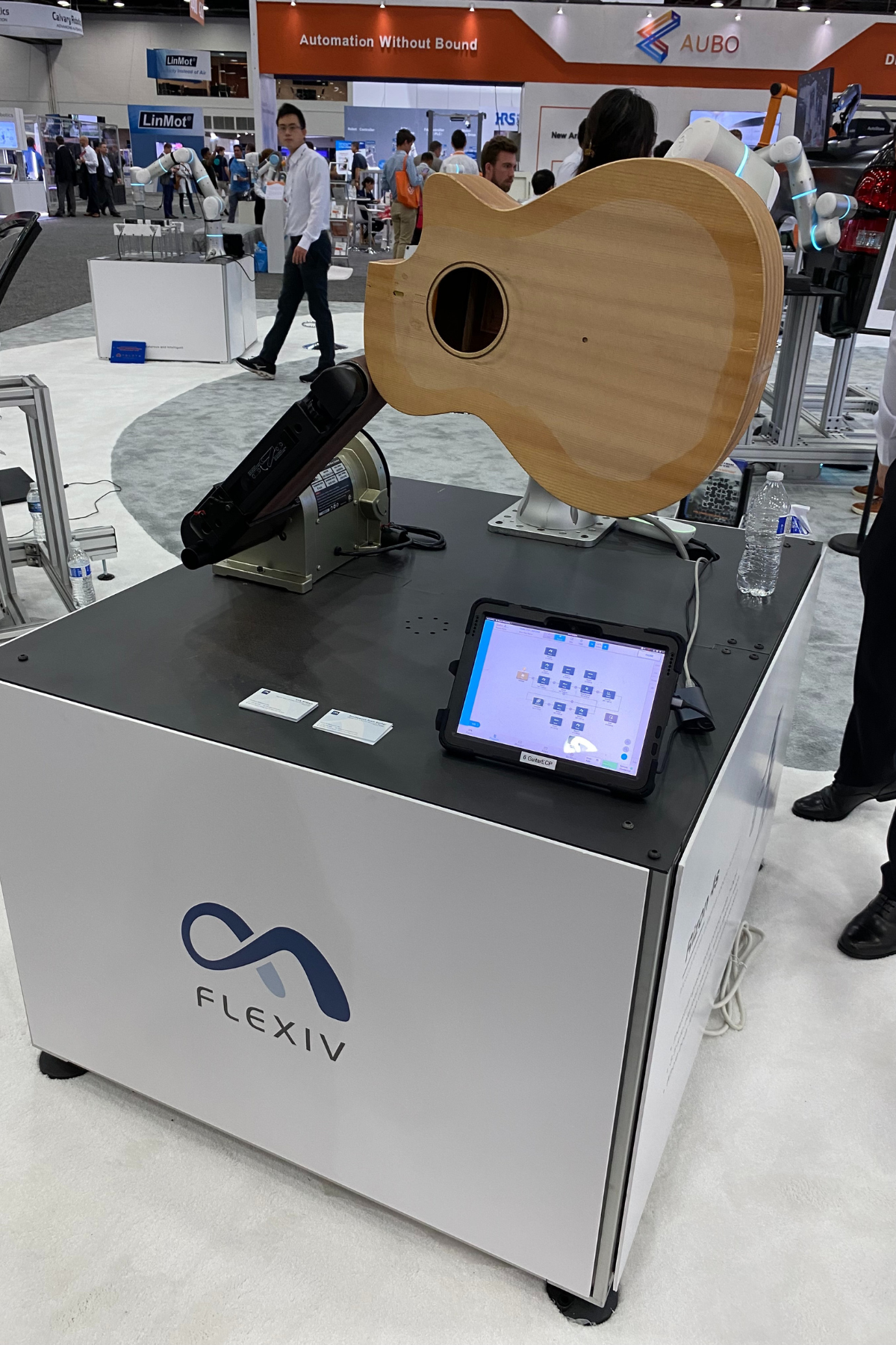 Image 1: Flexiv booth at Automate 2023 displaying robot precision by sanding a guitar.