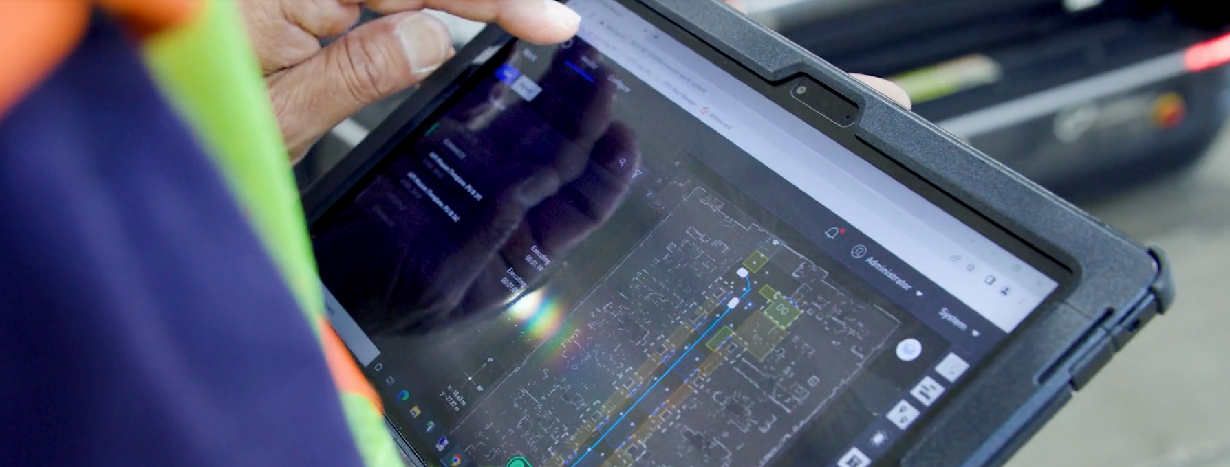 An operator in a manufacturing facility using fleet management software on a tablet.