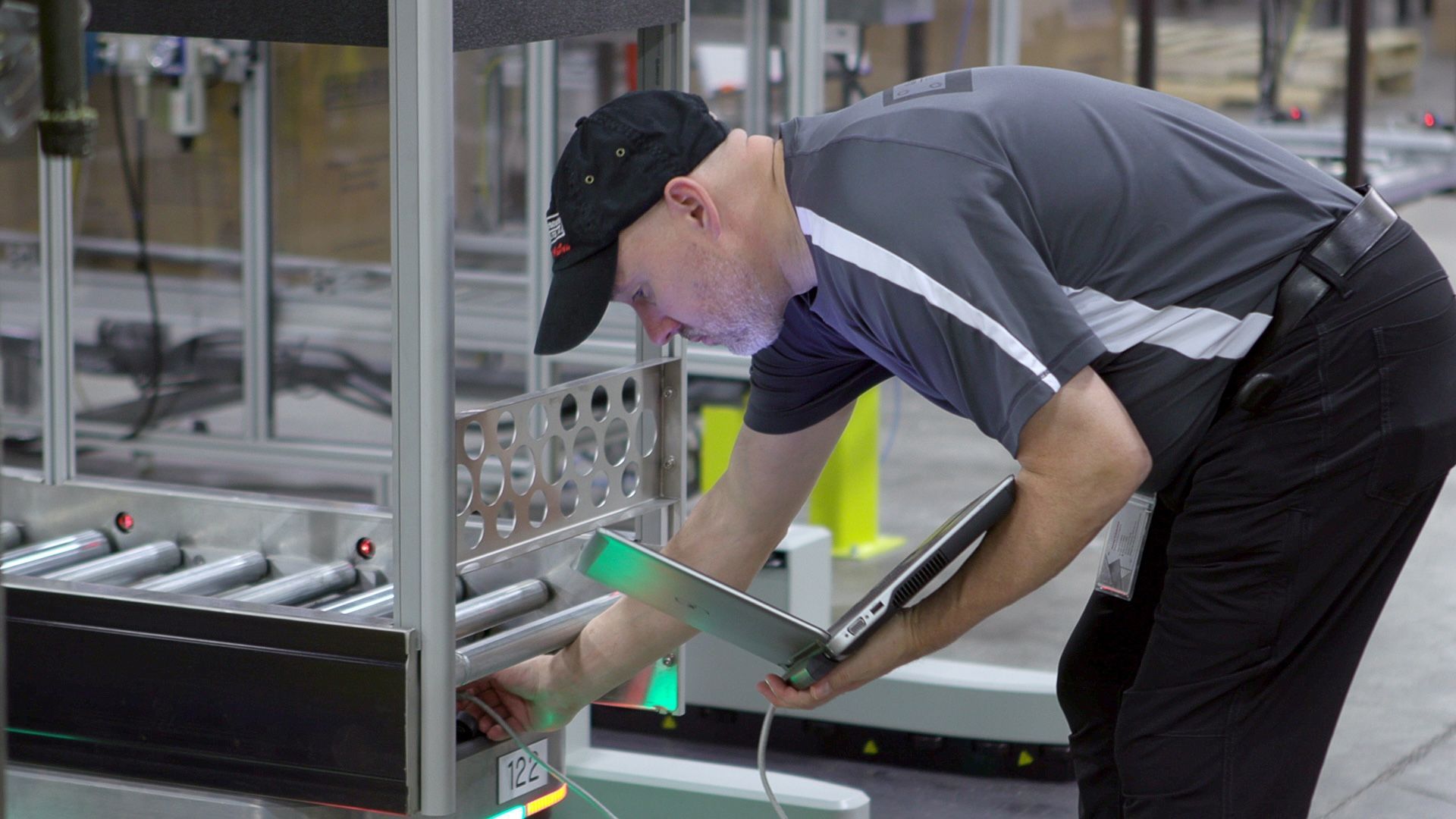 OTTO services team member with a laptop working near an autonomous mobile robot
