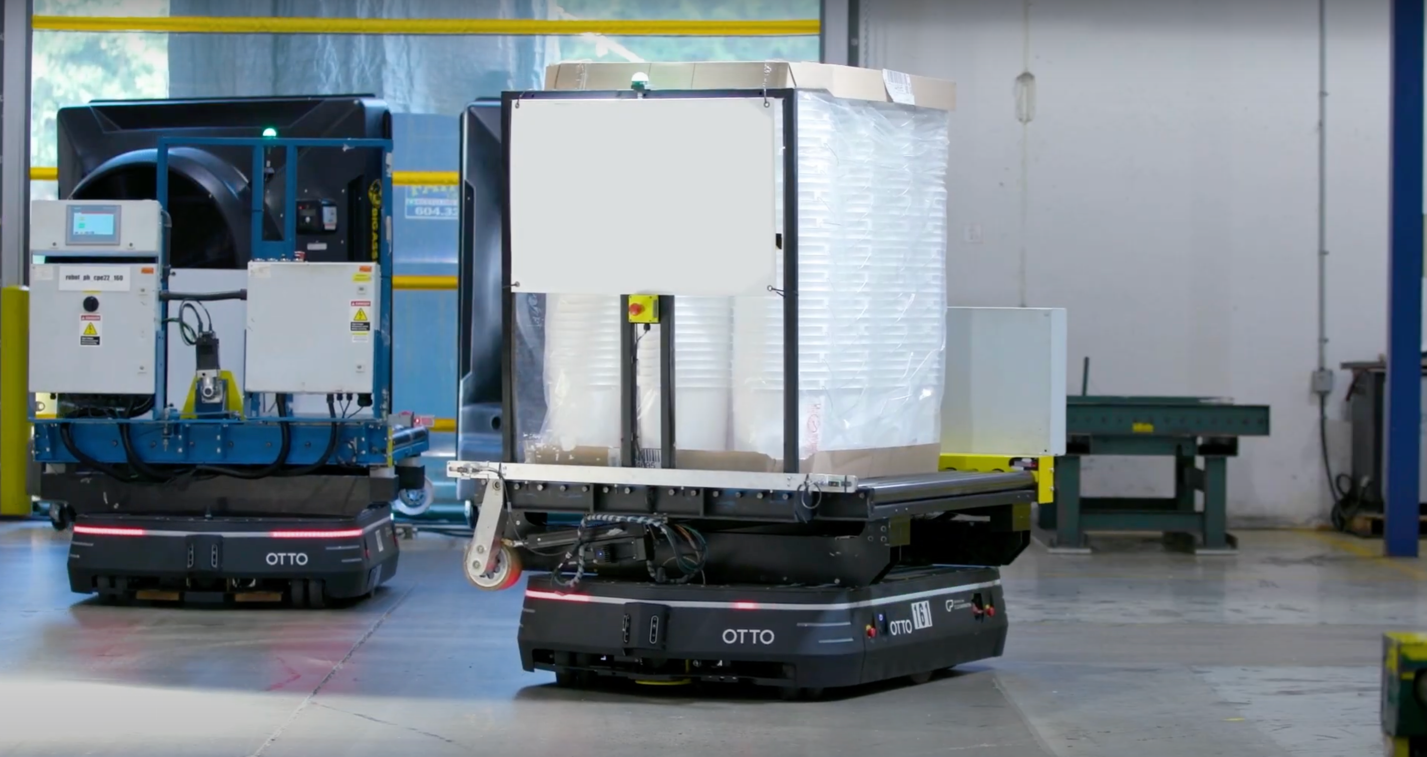 Large autonomous mobile robot moving buckets with conveyor attachment.