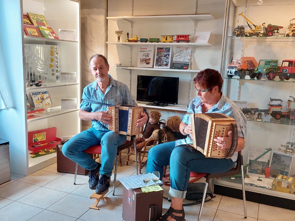 Zwei Personen spielen Handorgel in einem Ausstellungsraum des Museums