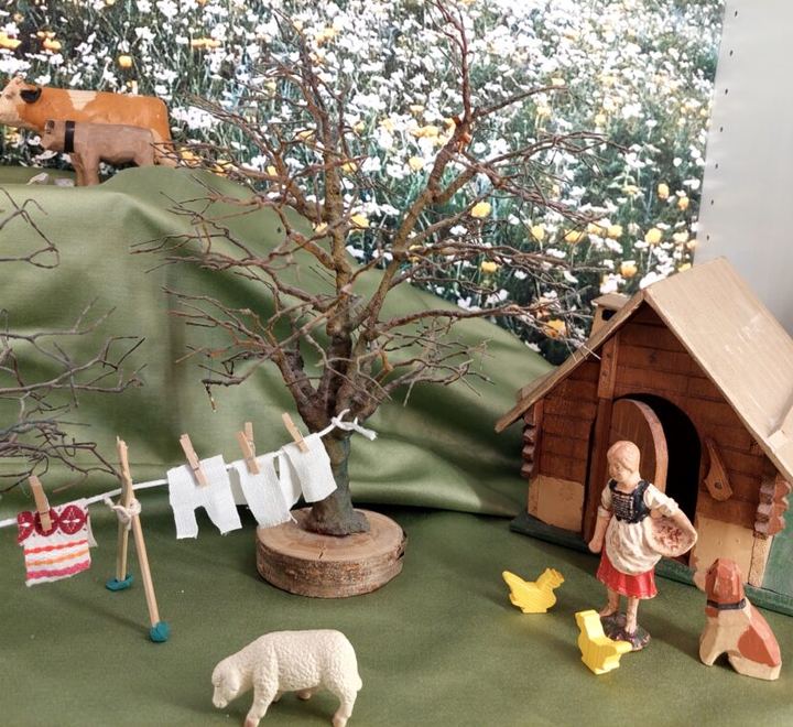 Bauernhofszene mit hölzernem Stall, Kuh, Schaf, Wäscheleine und einer Bauernfigur.