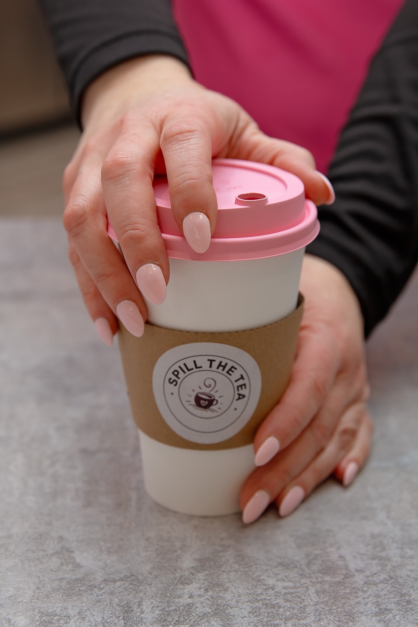Hands cradling a Spill the Tea cup