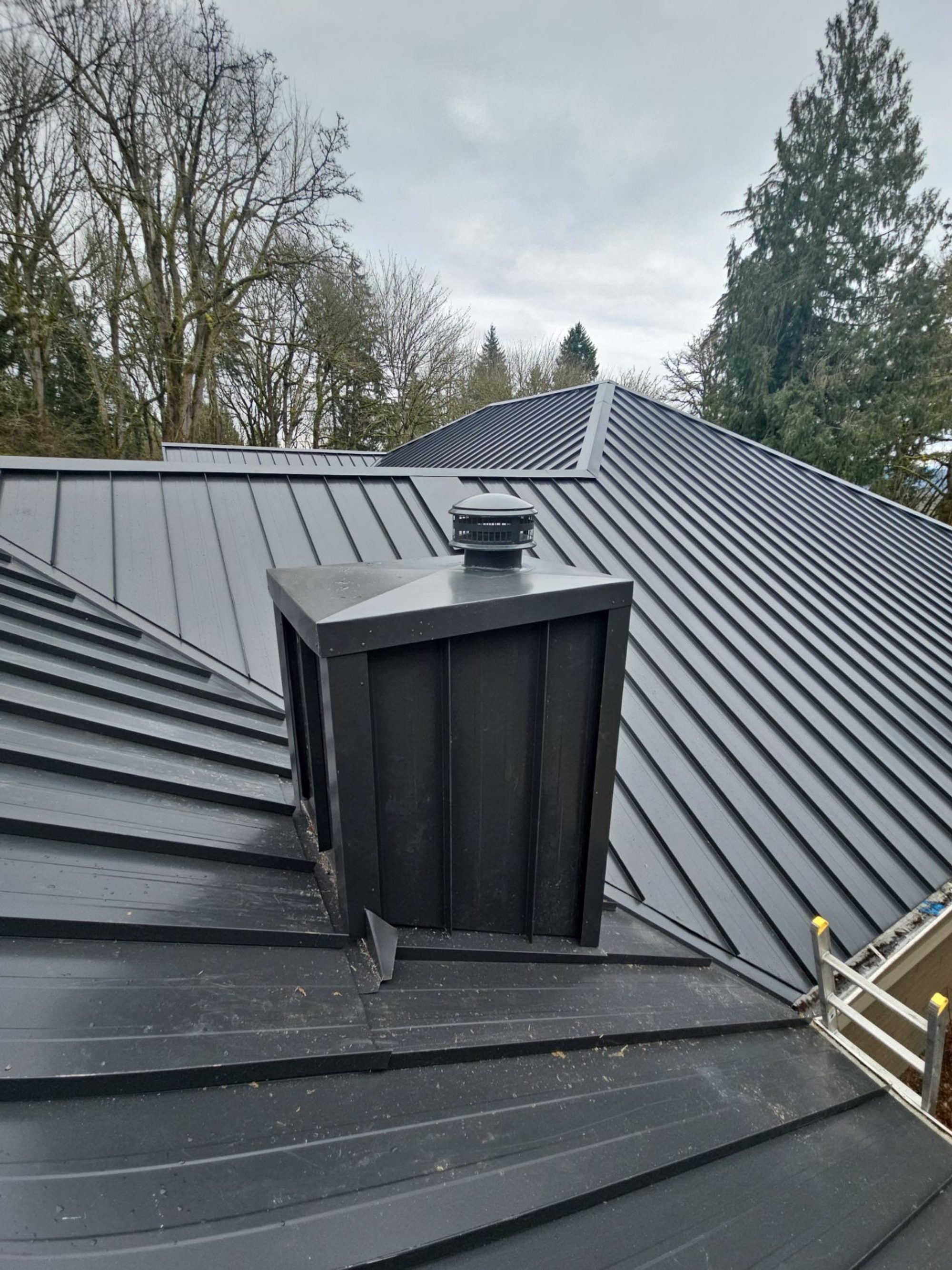 Amor Roofing Matte Black metal roof in Snohomish, ridge chimney flashing detail