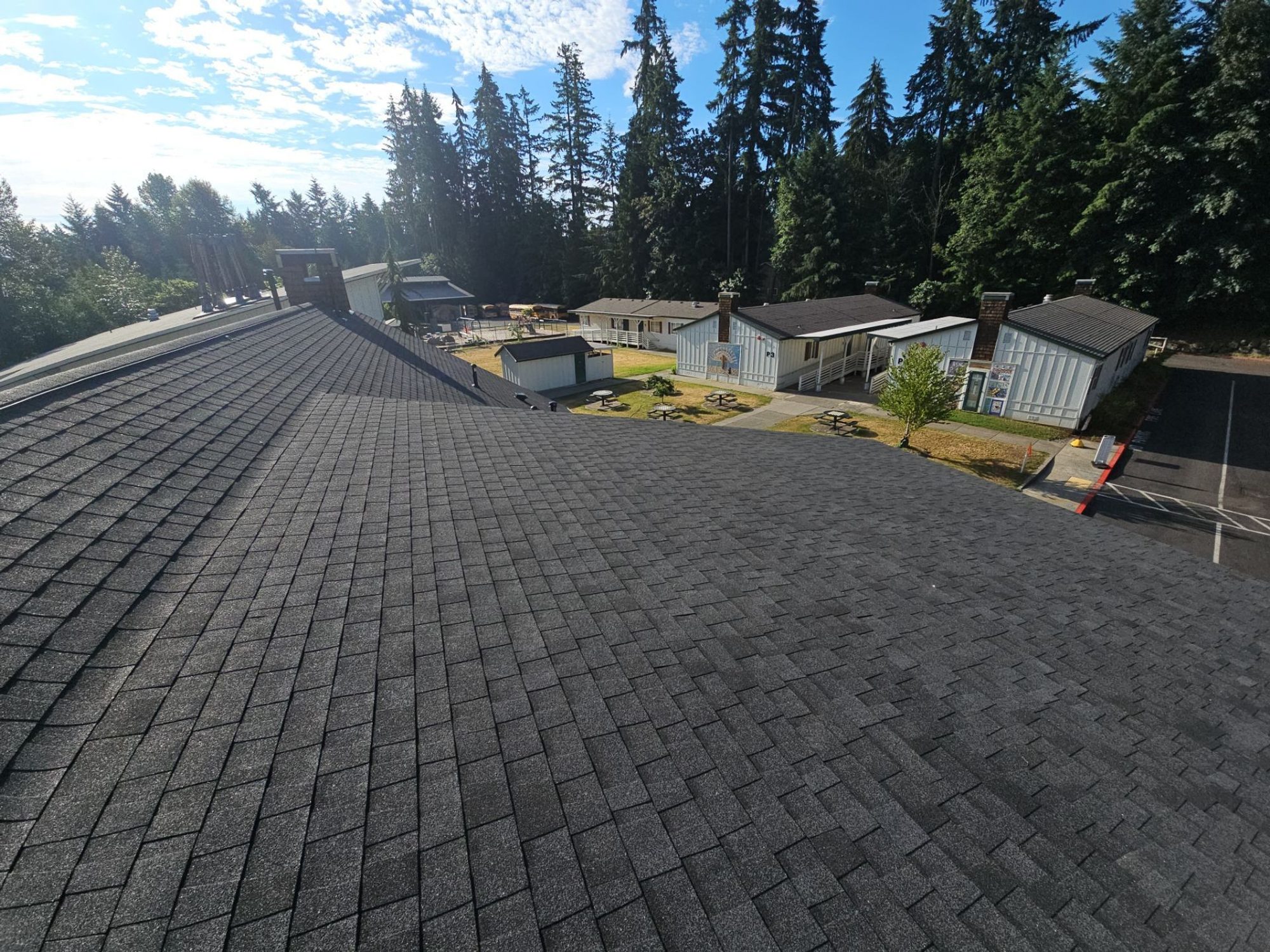 Finished Antique Black asphalt shingle roof plane with the campus buildings beyond, Woodinville, WA