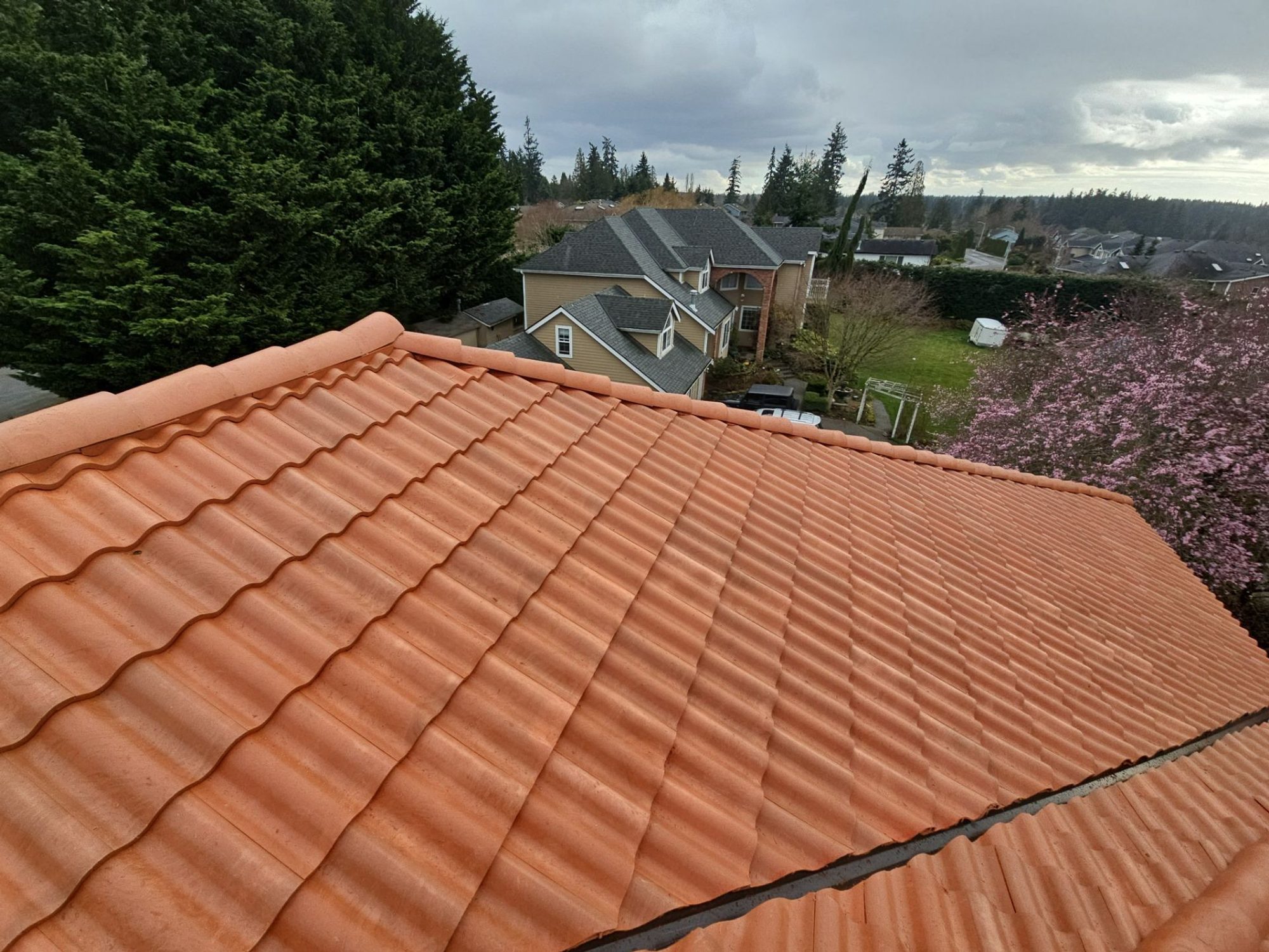 Finished Antique Clay Brava composite Spanish barrel tile roof plane with the neighborhood behind, Mukilteo, WA