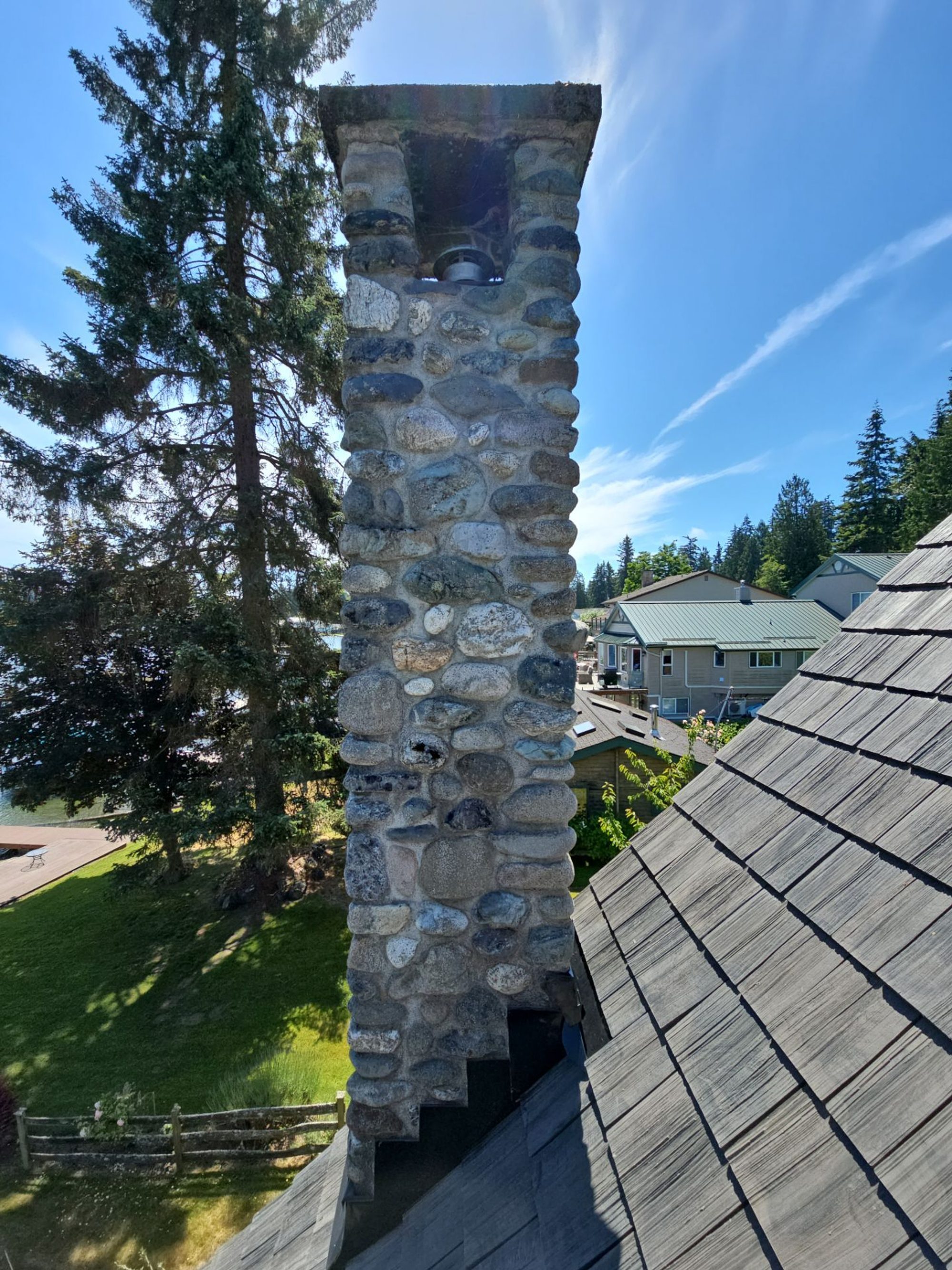 Amor Roofing Canyon Gray composite roof in Stanwood, stone chimney detail