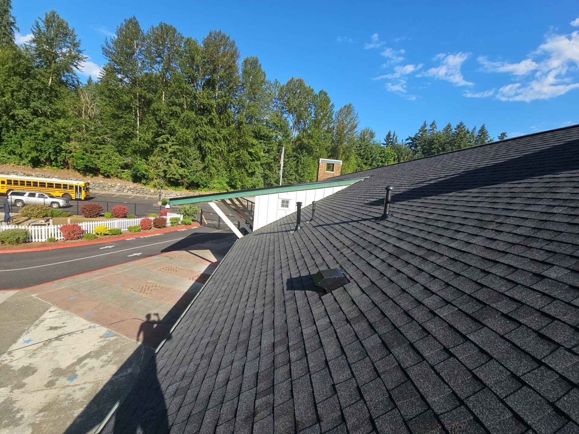 Finished Antique Black asphalt shingle roof ridge with vents under a blue sky, Building A, Woodinville, WA