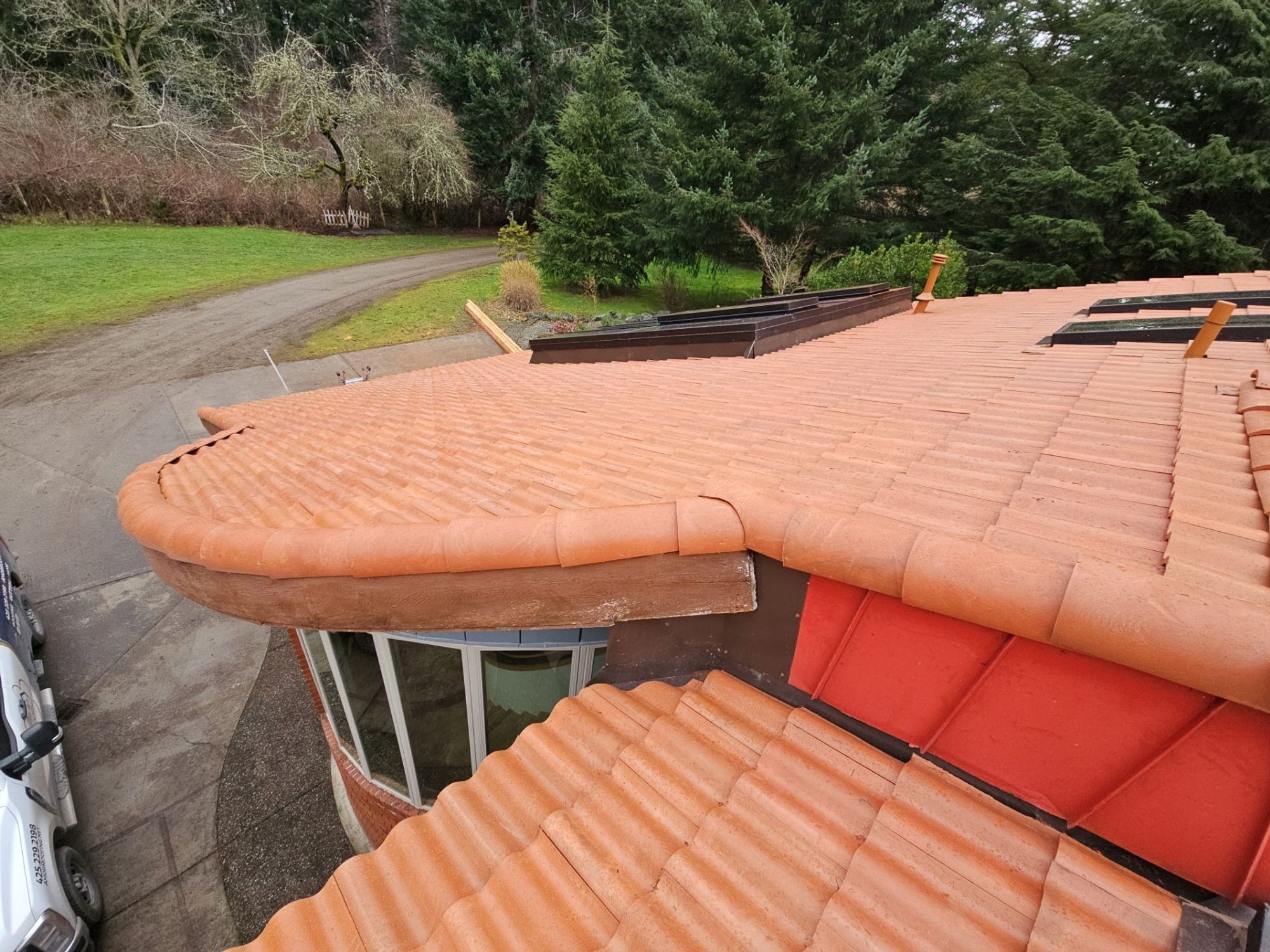 Curved eave of the Antique Clay Brava composite Spanish barrel tile roof over the glass entry, Camano Island, WA