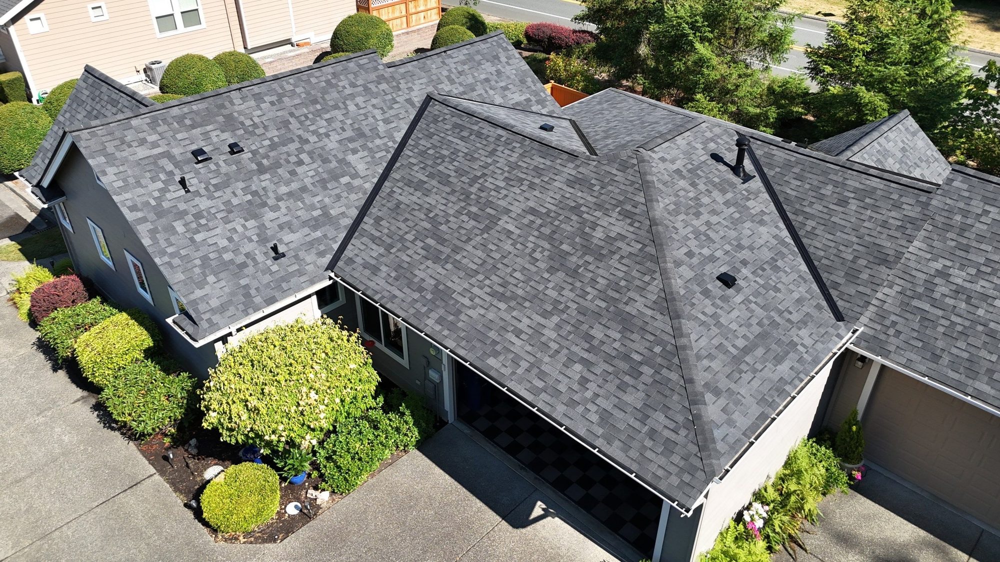 Rear aerial of the finished Malarkey Highlander Midnight Black asphalt shingle roof over the garage and patio, Redmond, WA