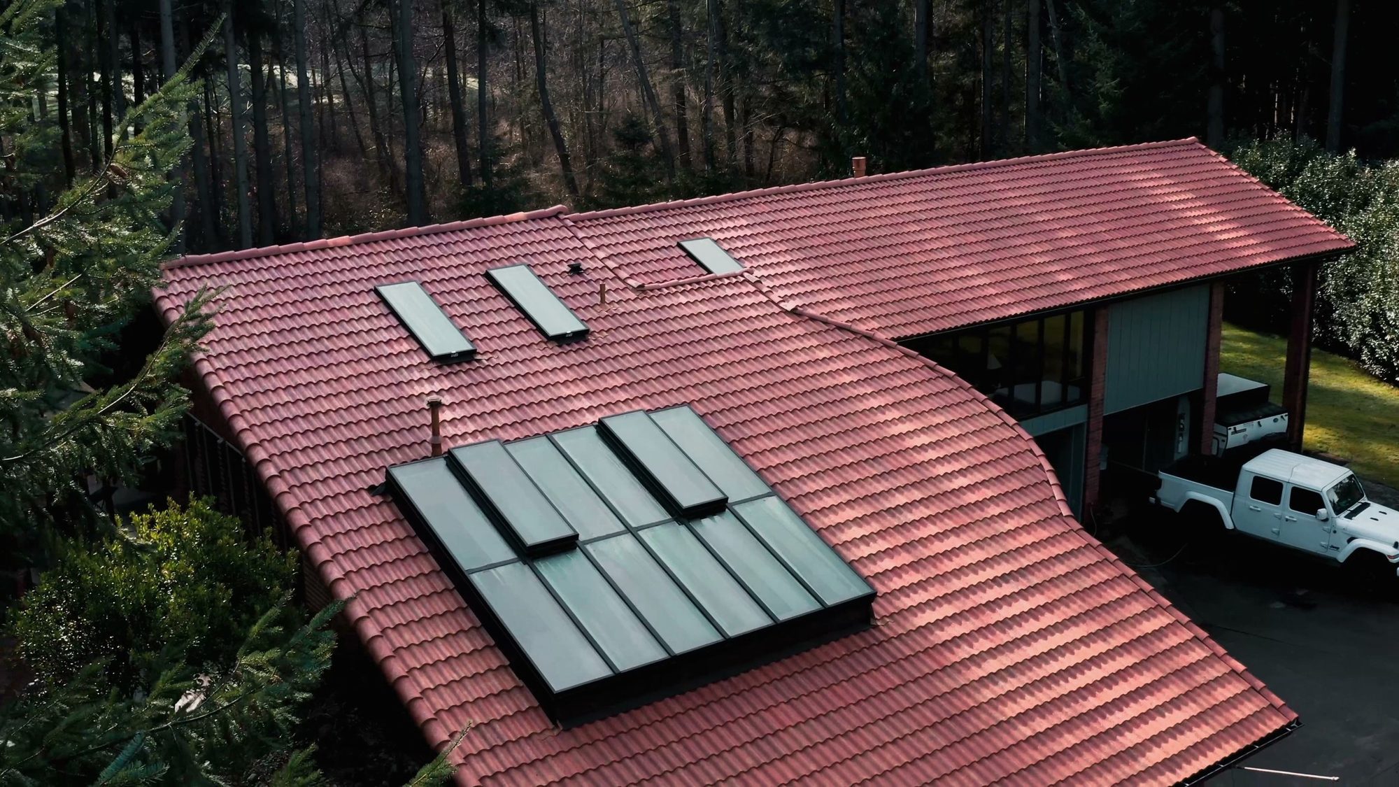 Aerial drone view of a finished Antique Clay Brava composite Spanish barrel tile roof with skylights on a Camano Island, WA home by Amor Roofing