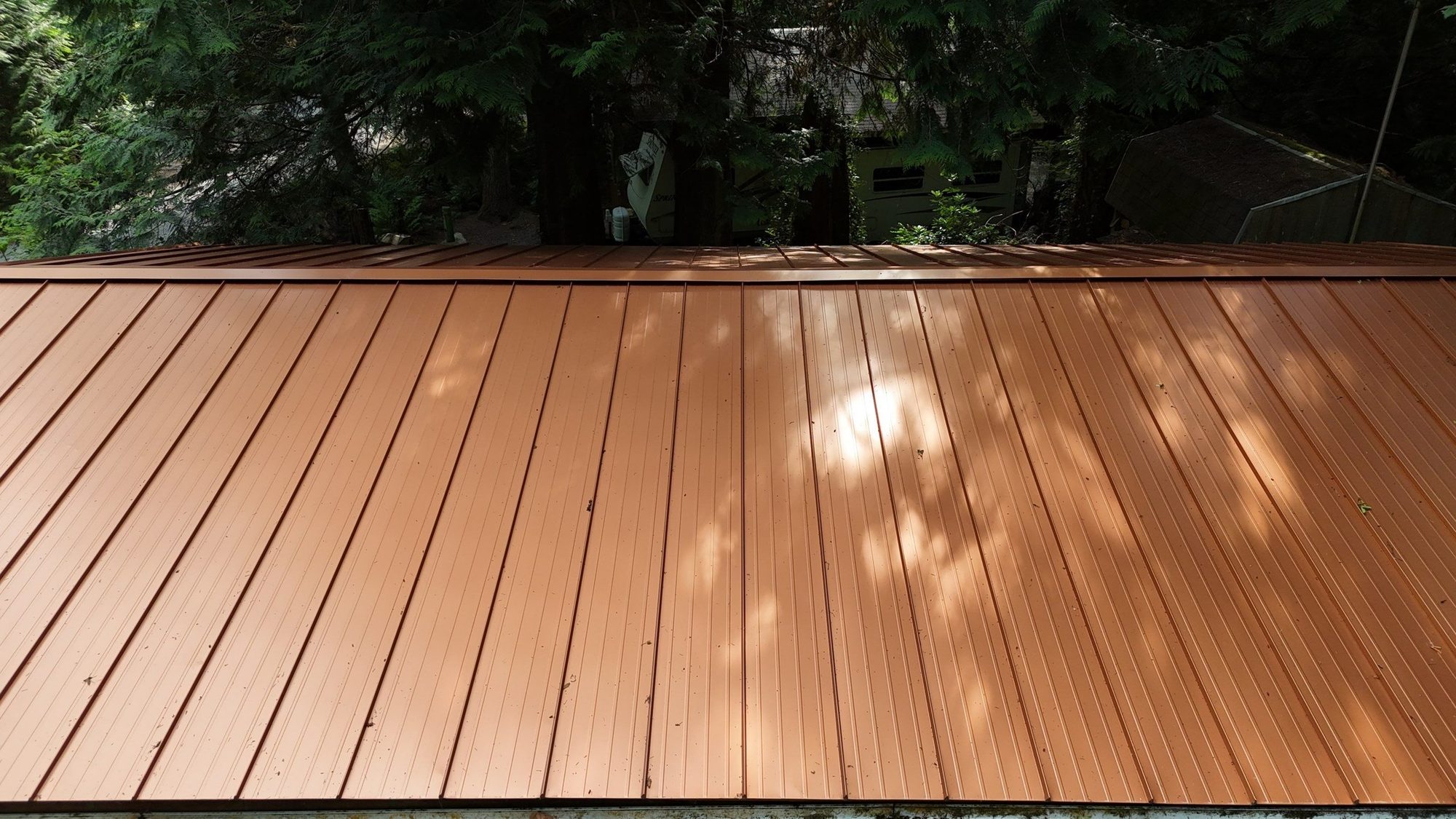 Aerial of the Copper Penny standing seam metal roof with the driveway and forest, Marysville, WA
