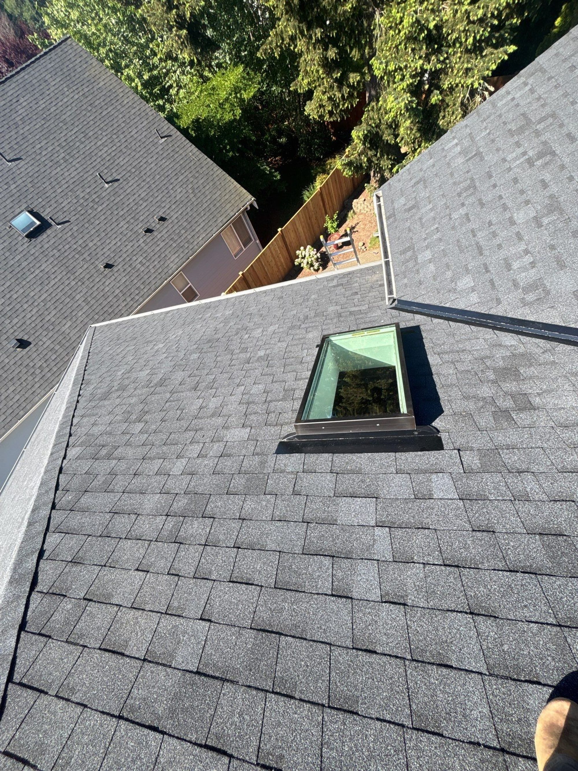 New skylight set into the Pabco Premier Antique Black asphalt shingle roof, from above, Bothell, WA