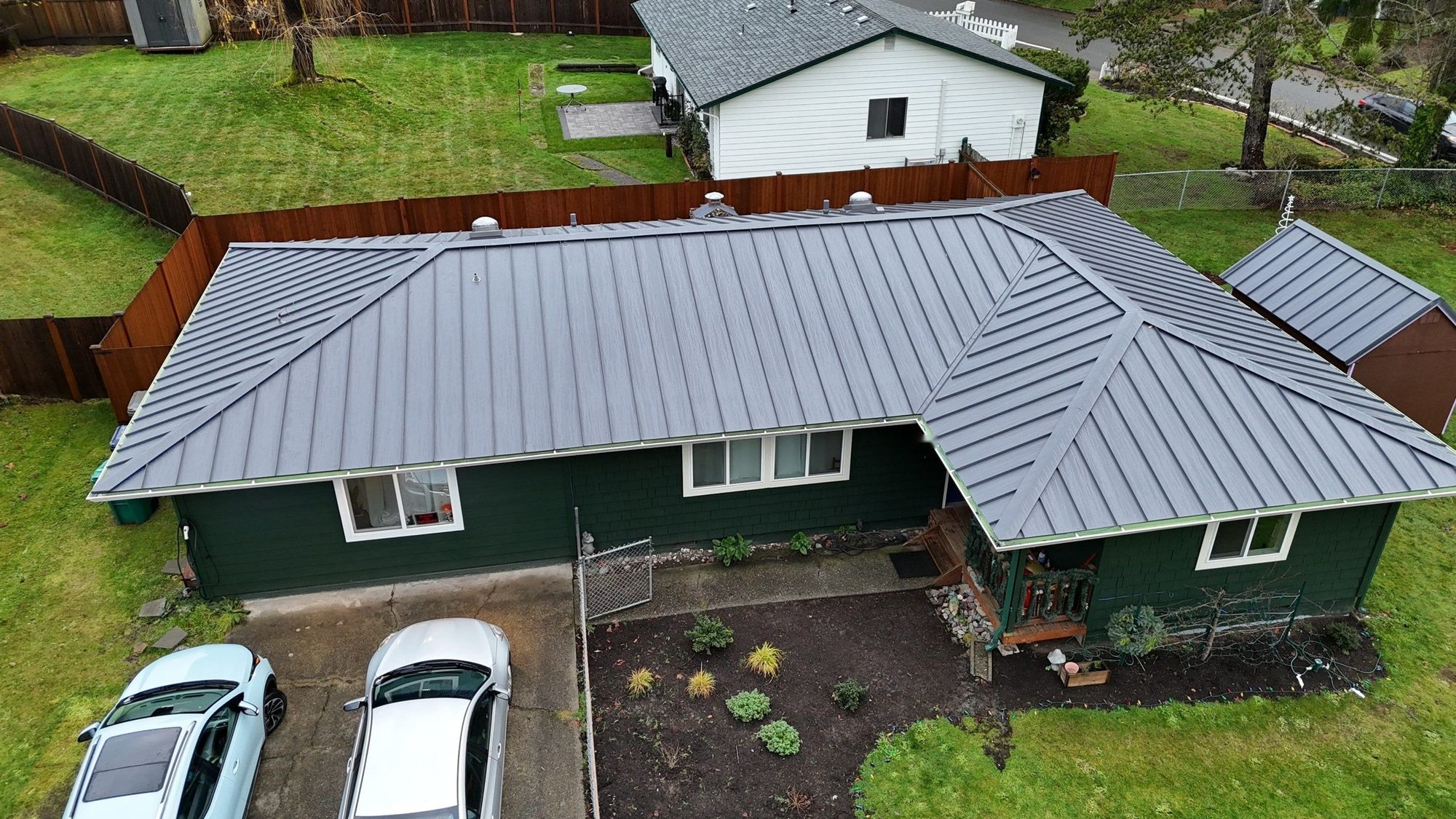 Aerial view of the finished Cascade Gray standing seam metal roof and front entry, Woodinville, WA