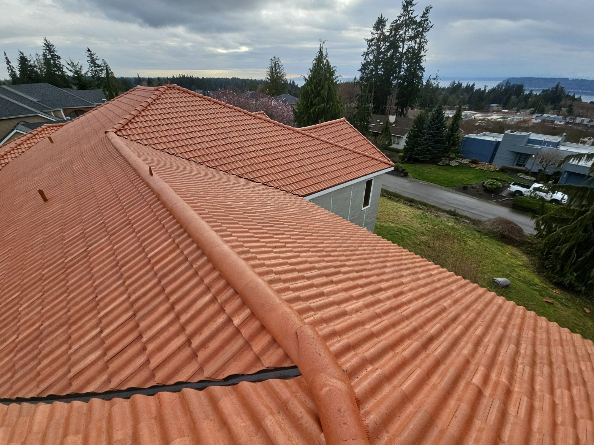 Hip and ridge caps of the Antique Clay Brava composite Spanish barrel tile roof looking toward the water, Mukilteo, WA
