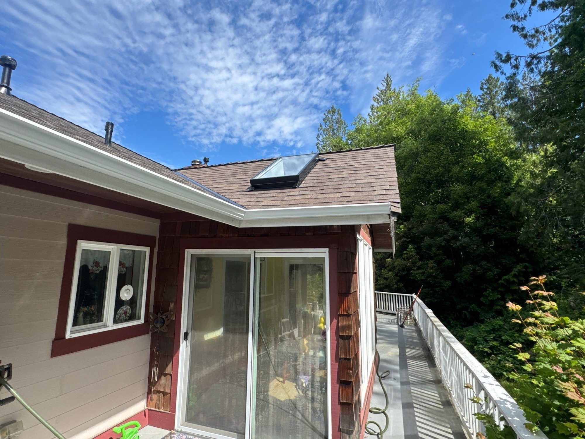 Skylight and roof edge of the Malarkey Heather Grey asphalt shingle roof seen from the deck, Lake Stevens, WA