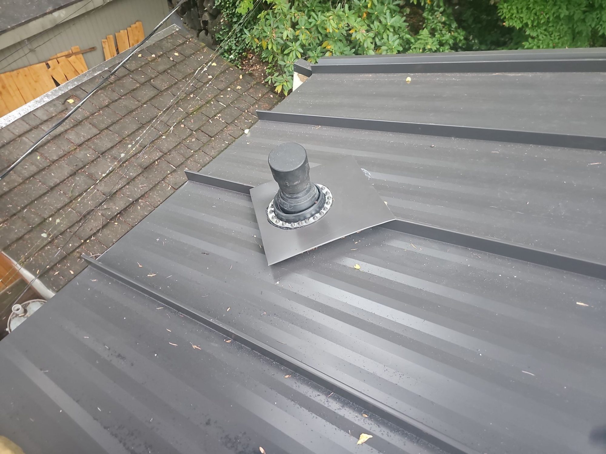 Hip of the Dark Bronze standing seam metal roof from above with the concealed-fastener seams, Bellevue, WA