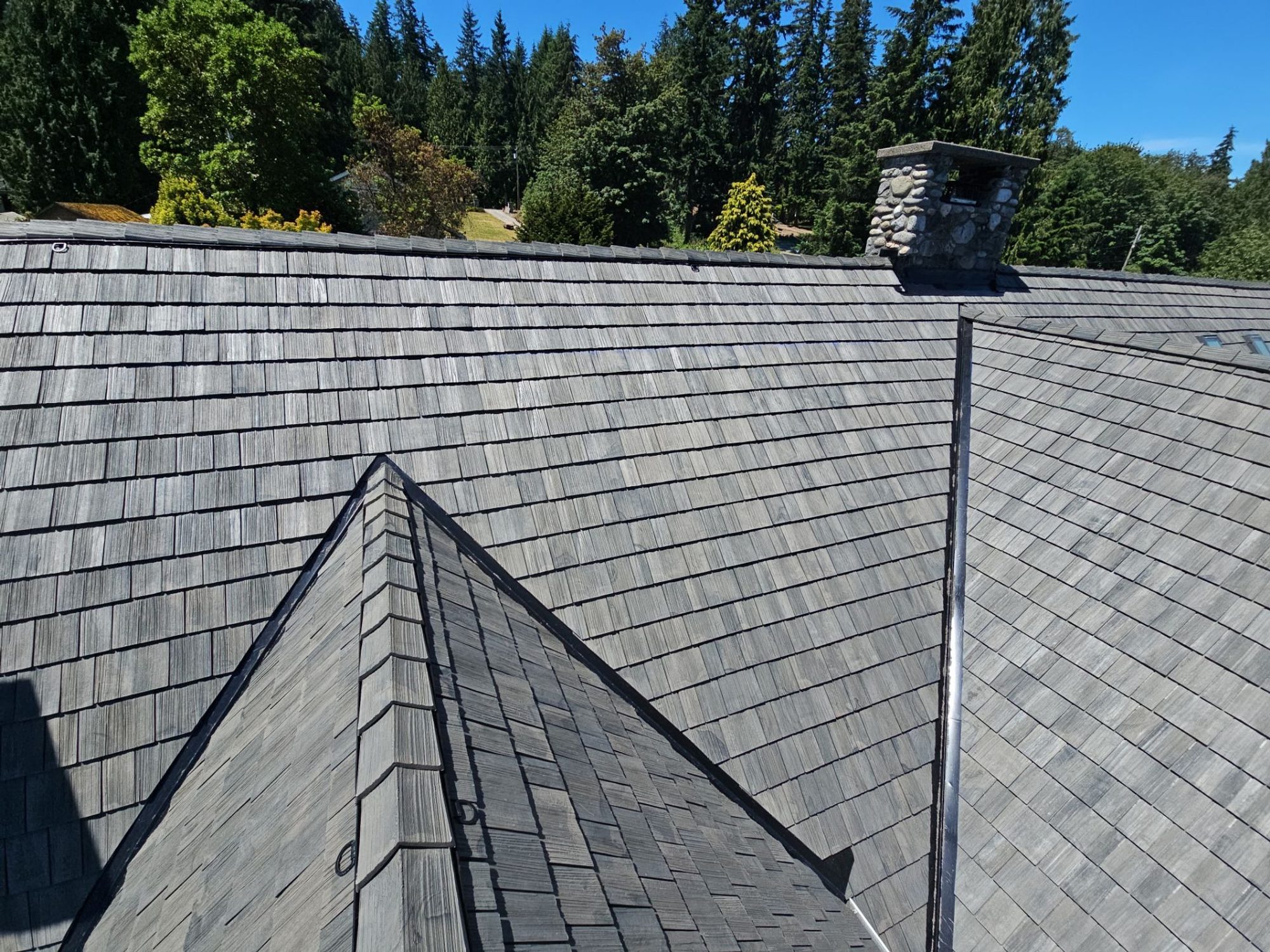 Amor Roofing Canyon Gray composite roof in Stanwood, after aerial ridge chimney